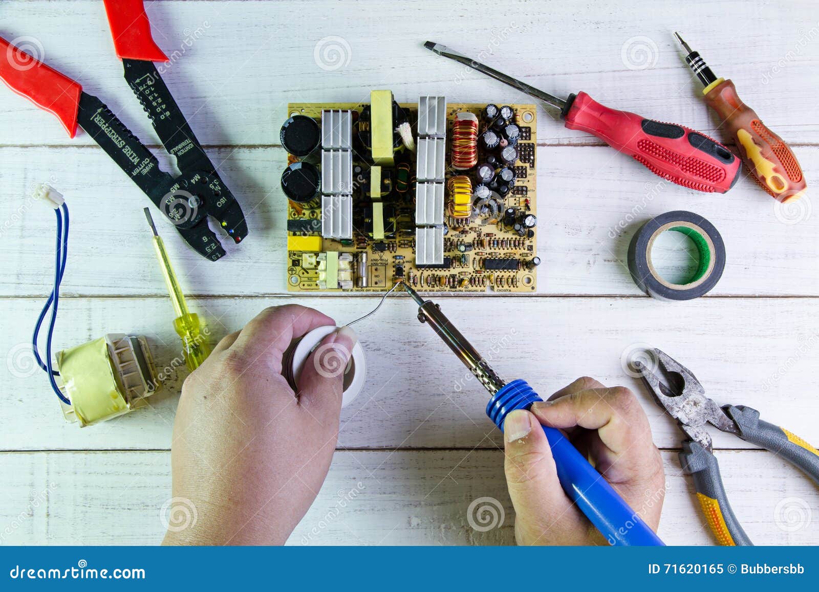 Serviceman Soldering Circuit Board with Soldering Iron Stock Image