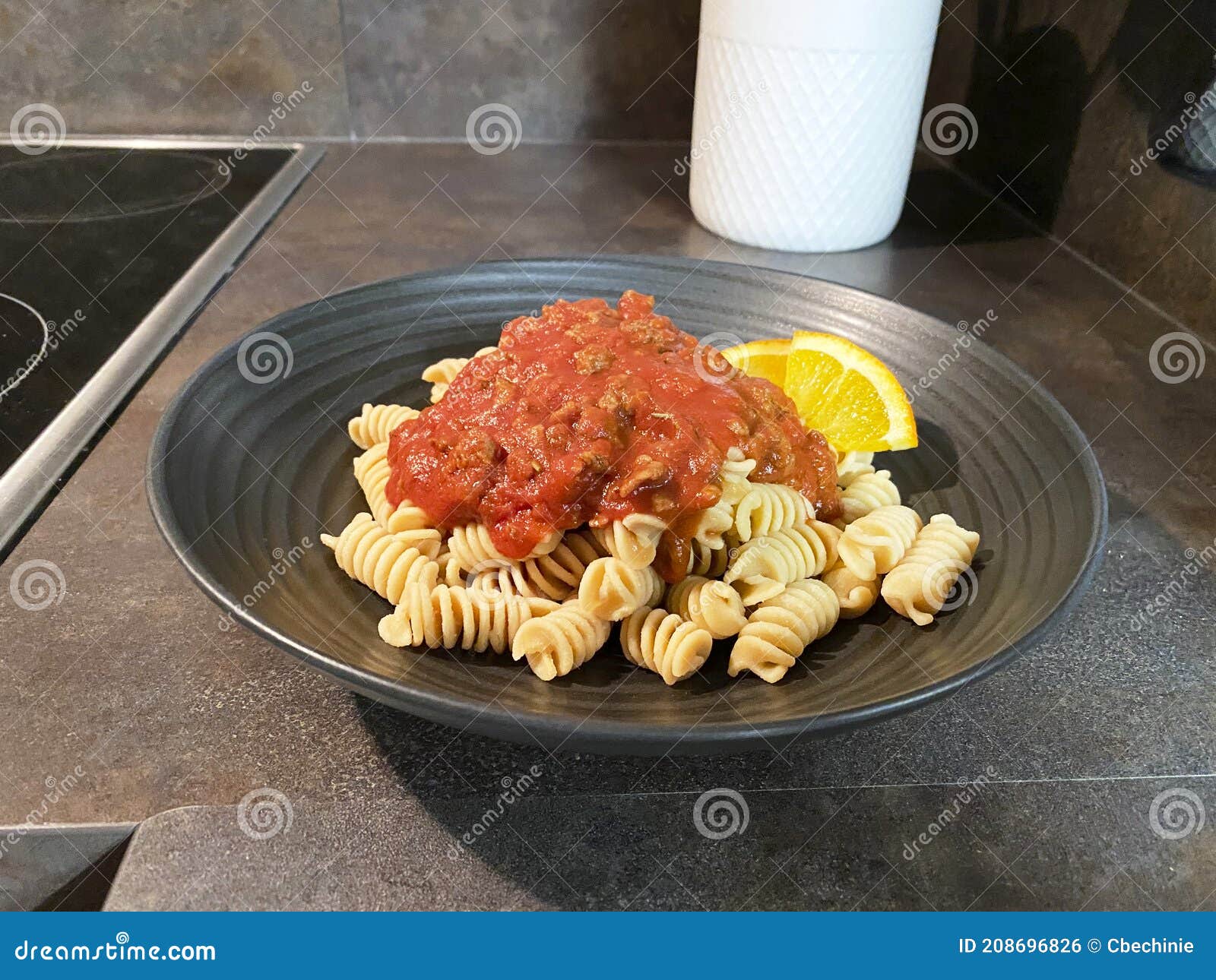 A Serving of Pasta with Tomato Sauce on a Dark Plate Stock Photo
