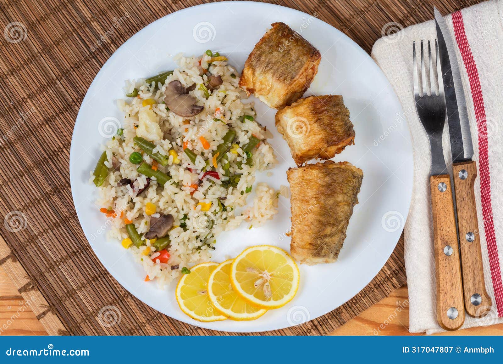 serving of fried hake hubbsi pieces with rice and vegetables