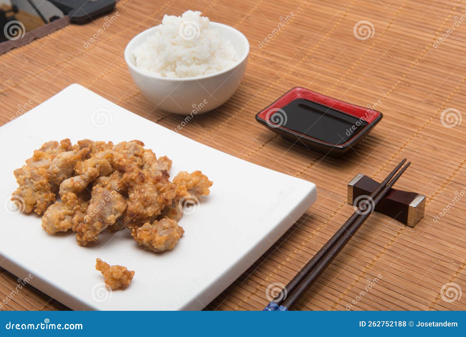 sesame chicken dish and chopsticks on bamboo placemat