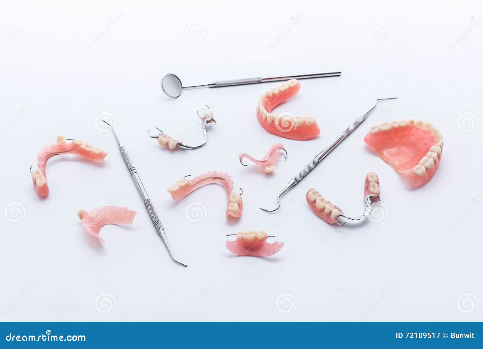 set of dentures and dental tools on white background