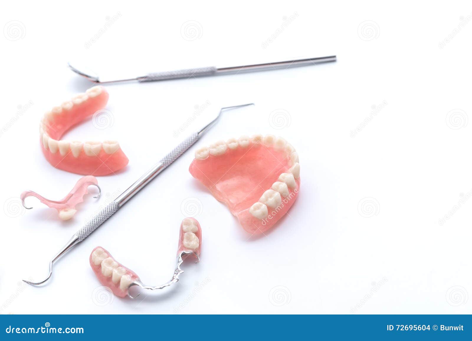 set of dentures and dental tools on white background