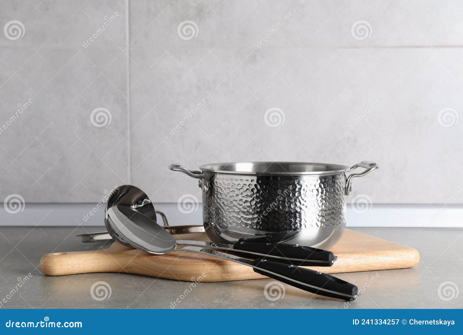 Set of Different Cooking Utensils on Grey Countertop in Kitchen Stock