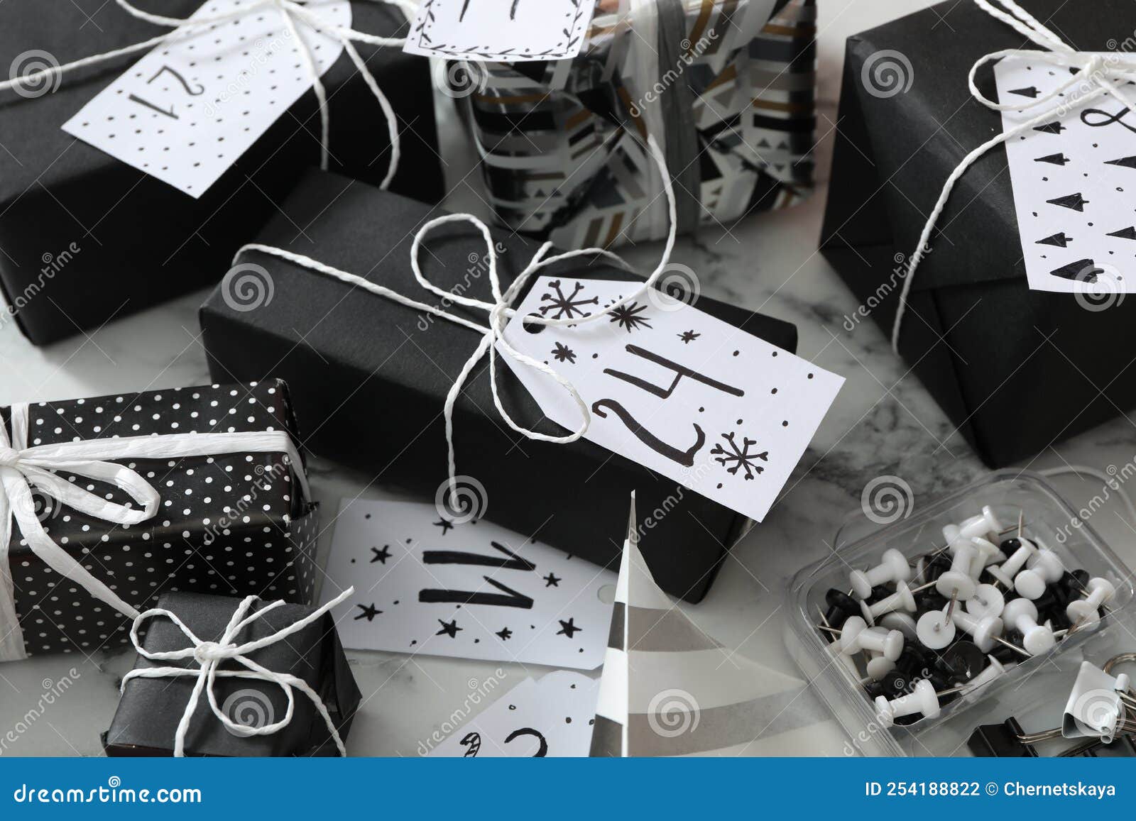 Set of Gift Boxes and Pins on White Marble Table. Creating Advent