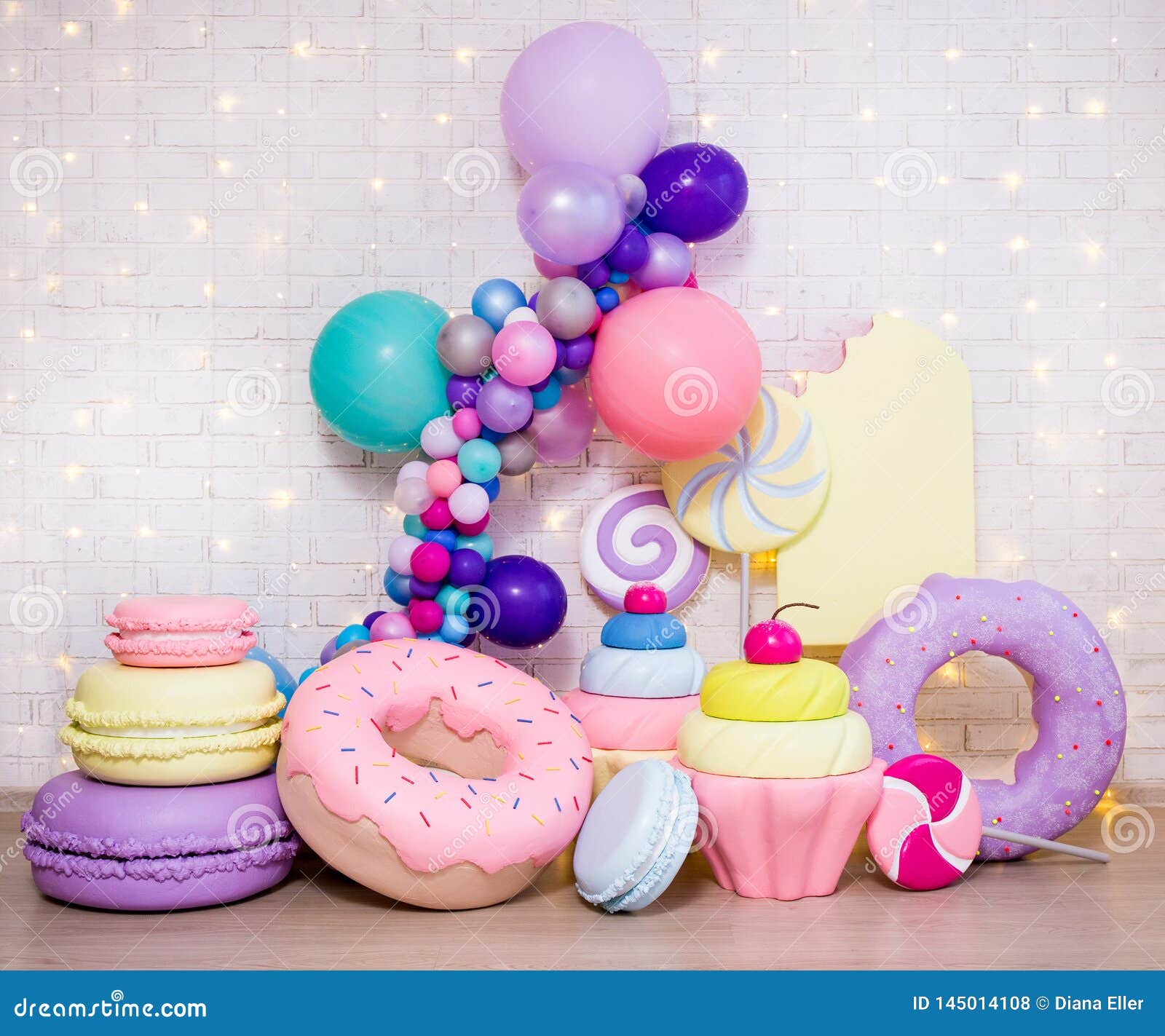 Set Of Huge Artificial Sweets And Pastry Decorations Over White Brick