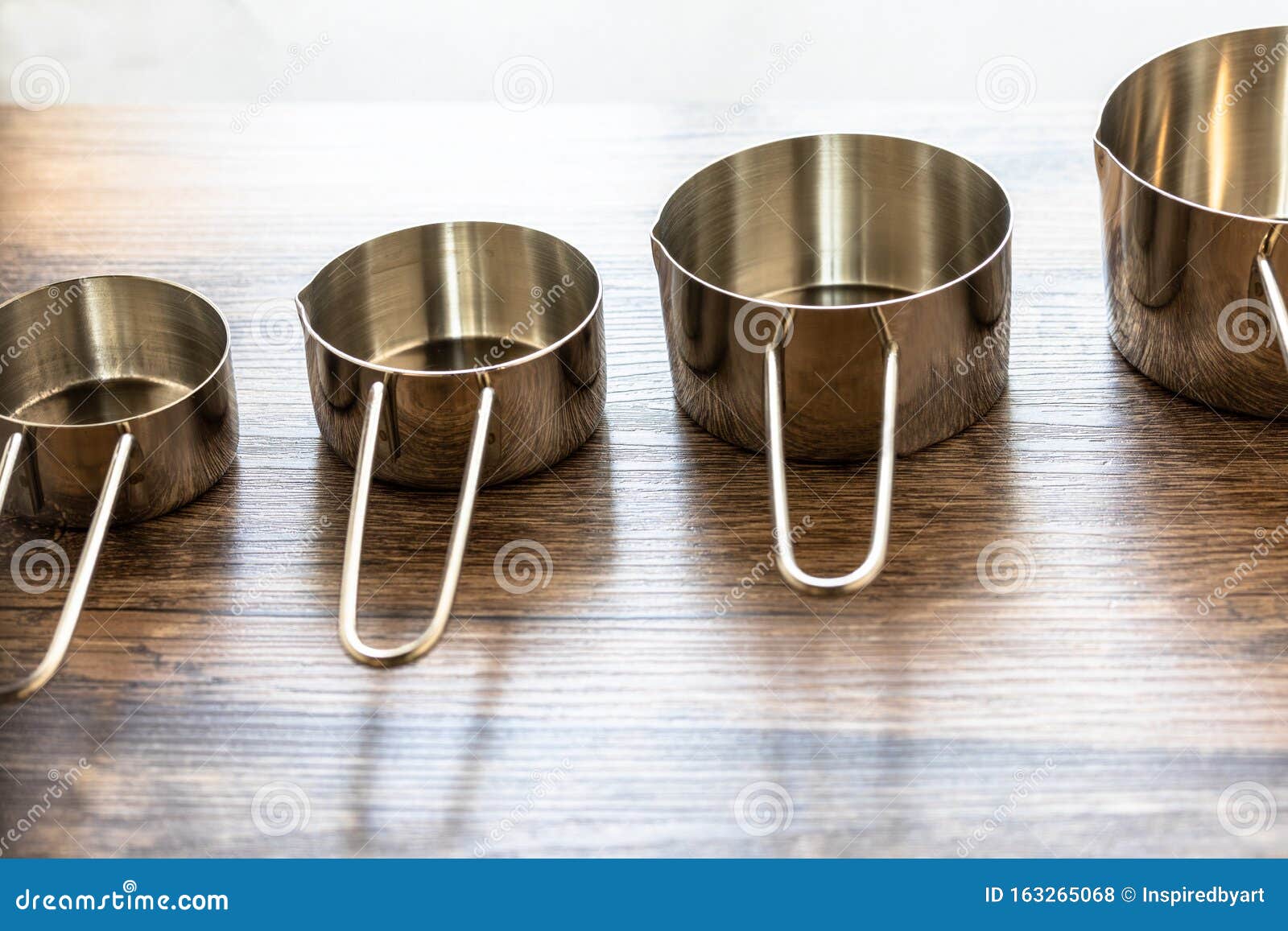 Set of Measuring Cups Made from Stainless with a Handle on Wooden Tabletop Stock Photo Image