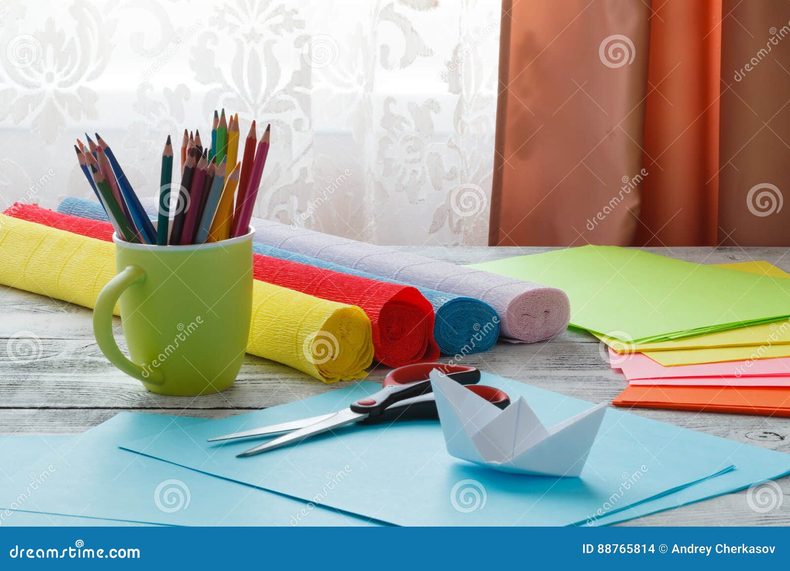 Set Of Origami Boats And Square Sheets Of Colored Paper On A