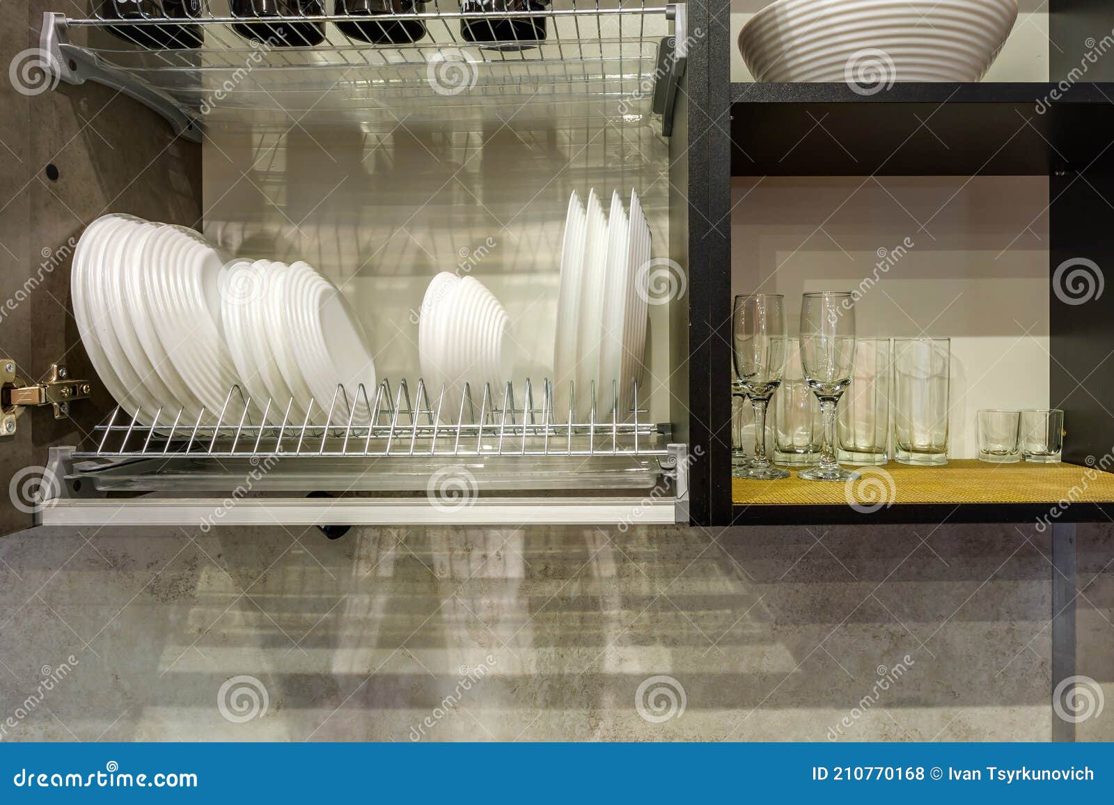 Set of Plates, Cups and Wine Glasses on the Shelf in the Kitchen