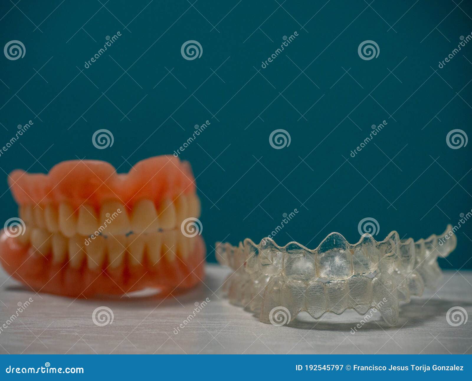 a set of teeth, together with an invisaling braces on a blue background