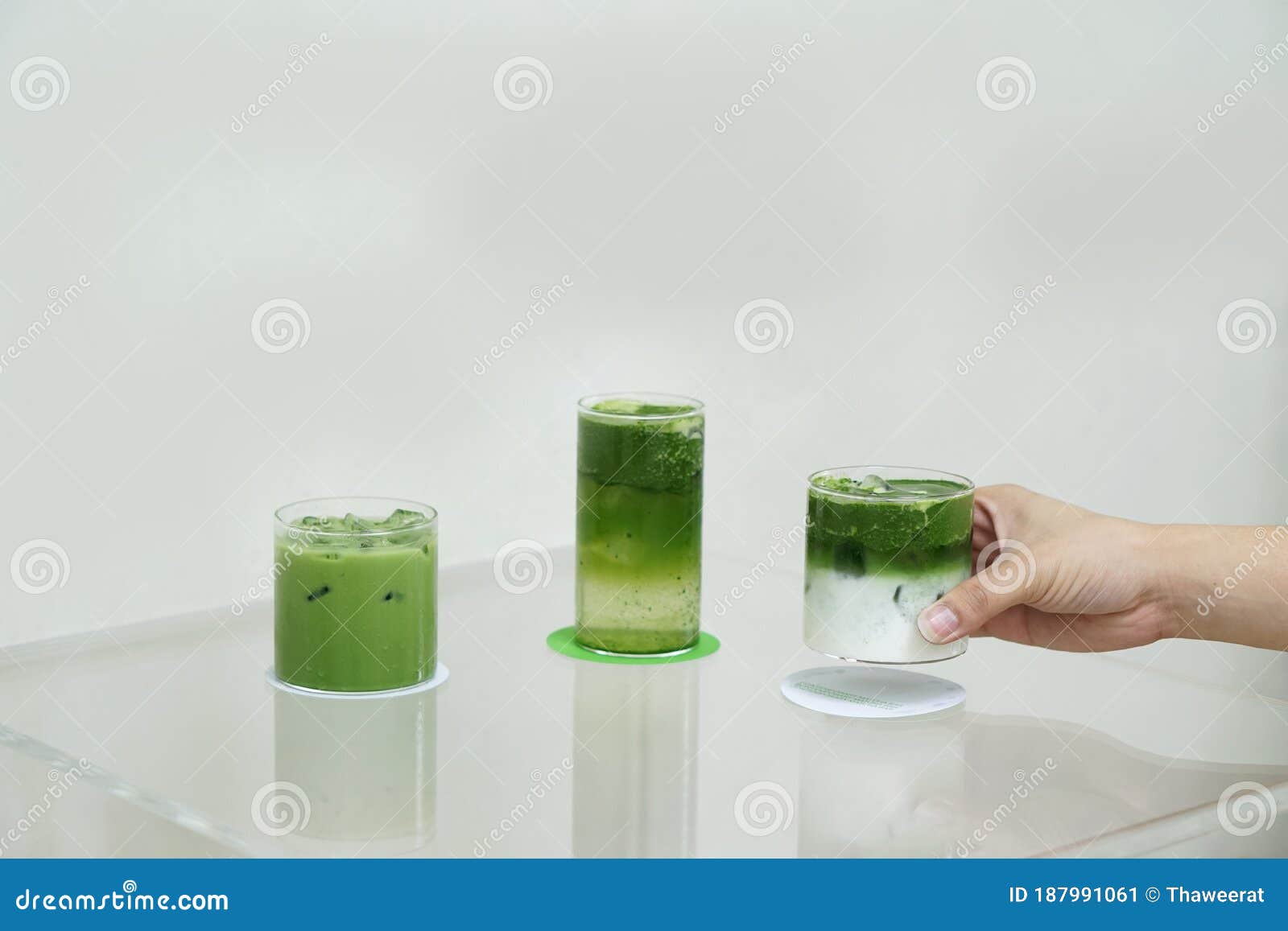 Premium Photo  Two glasses of iced matcha green tea mixed with ice cubes  and milk in high glasses on kitchen table cold matcha latte in home  interior green mocktail with ice