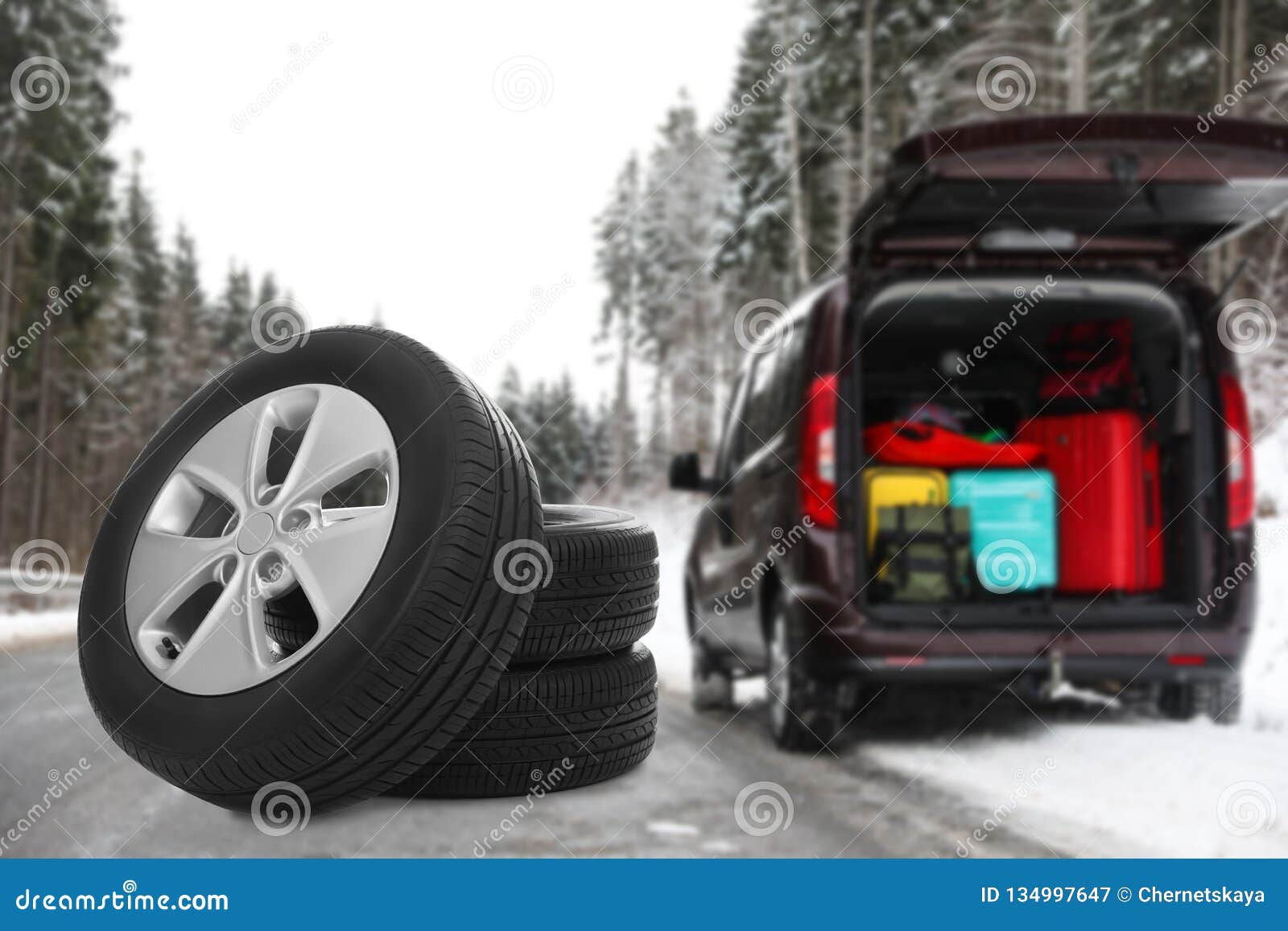Set Of Winter Tires Near Broken Car With Open Trunk On ...