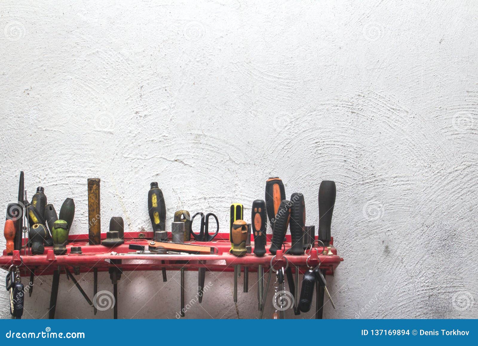 A Set of Working Construction Tools on a White Plastered Wall Stock