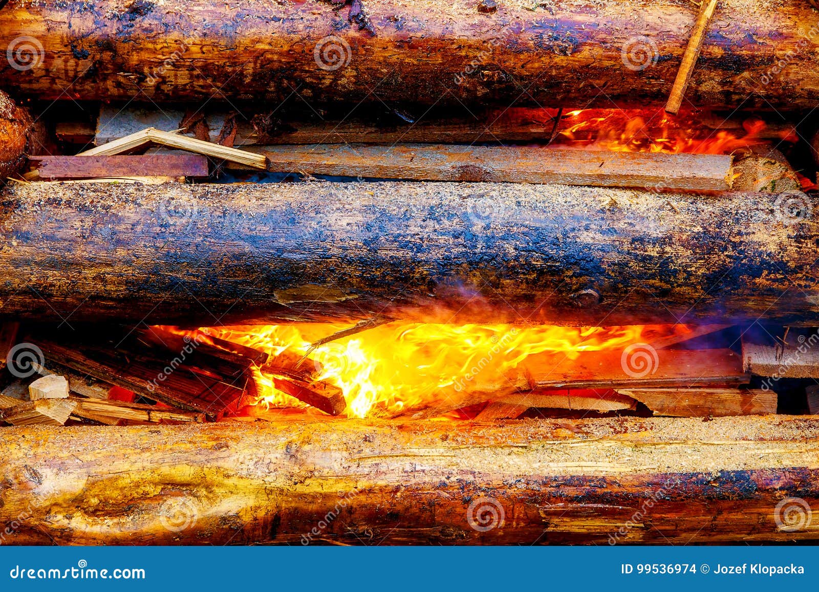 Setting Big Bonfire Made of Logs on Fire with Torch. Stock Photo Image of burn, glow 99536974