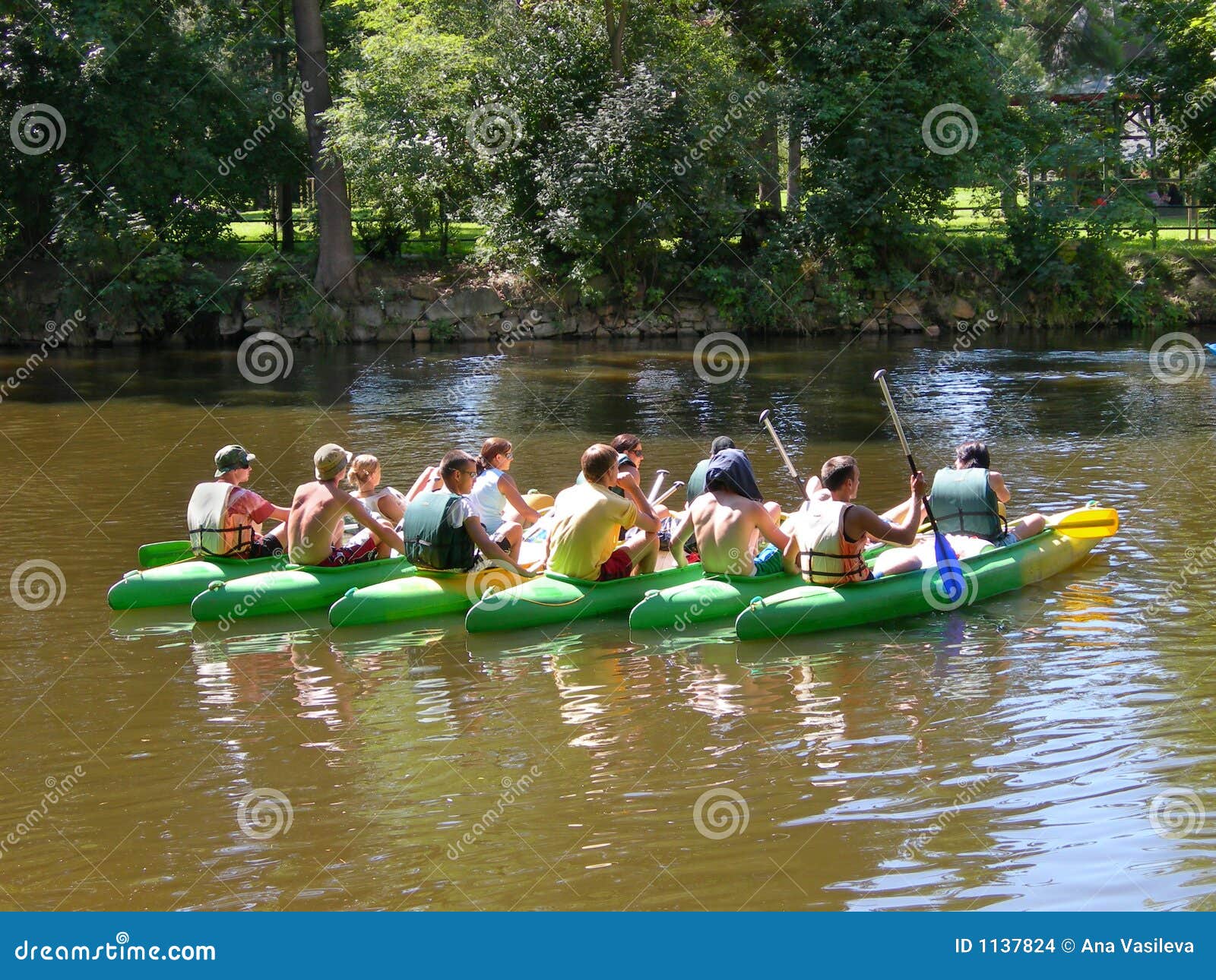Seven Canoes with Young People Grouped in the Middle of the River Stock