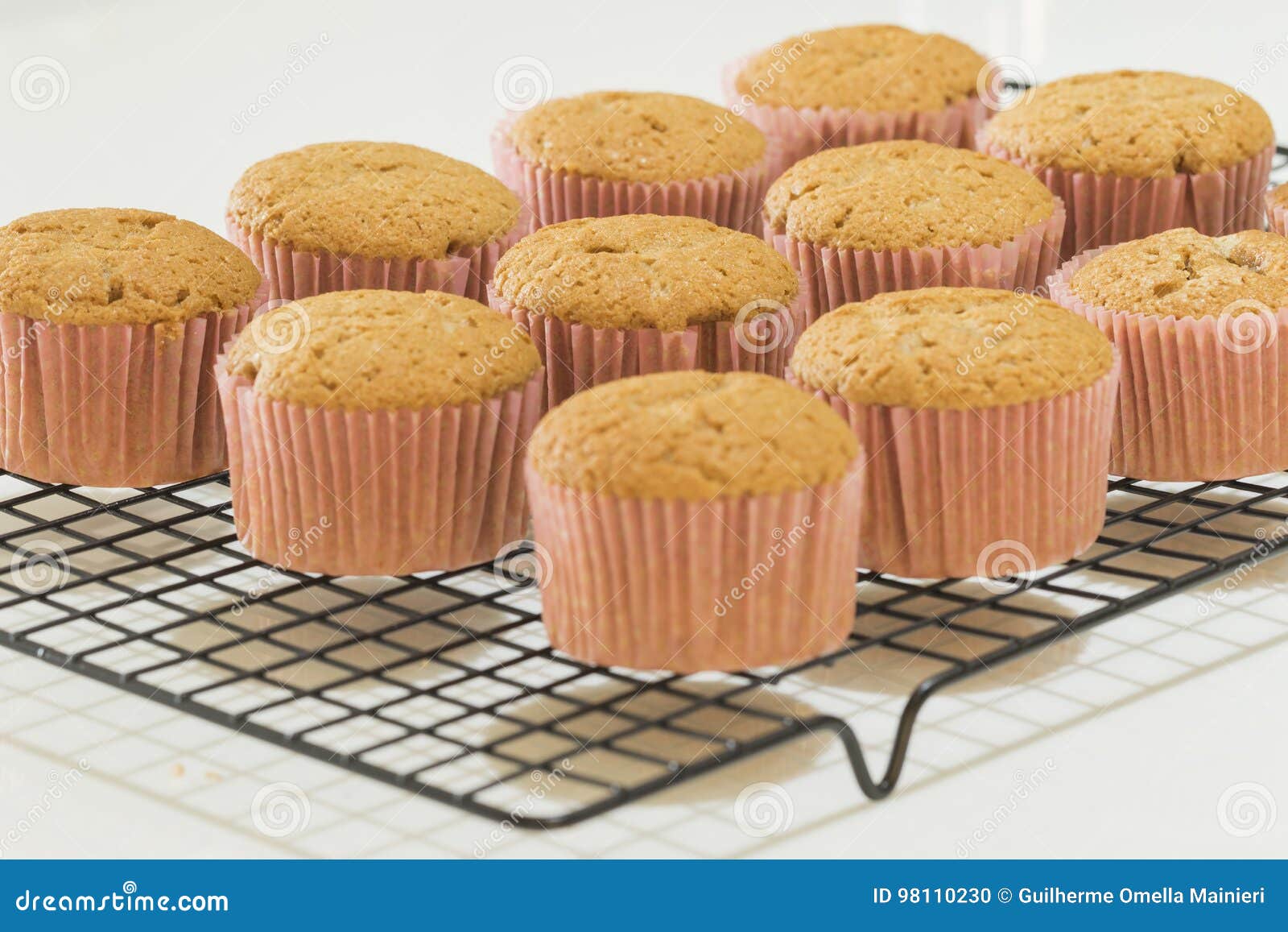 Seven Newly Made Cinnamon Cupcakes in a Cooling Rack Stock Photo