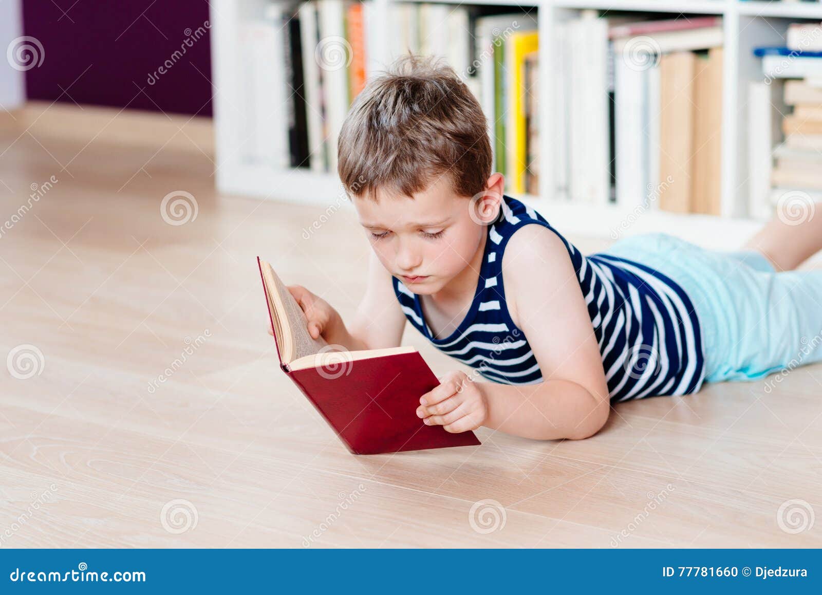 Seven Years Old Boy Reading a Book in Library. Stock Photo Image of