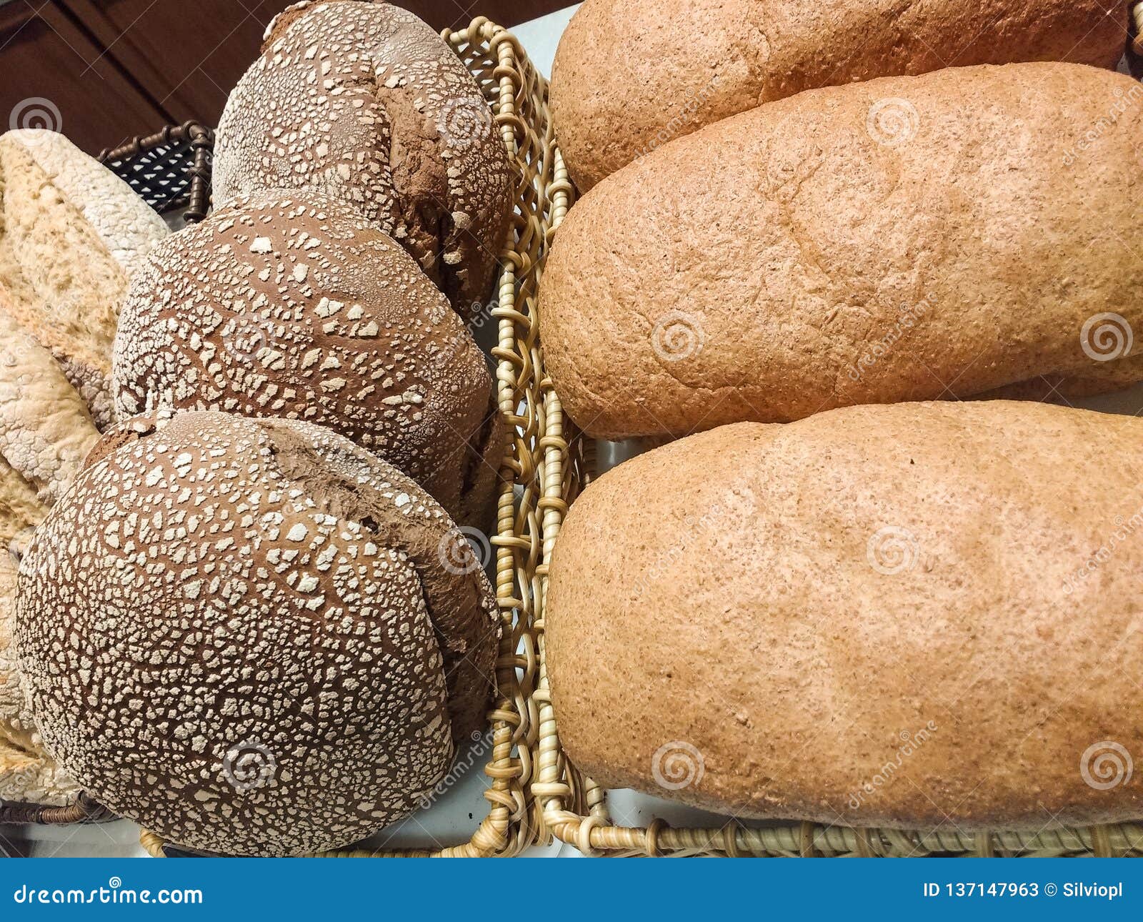 Several Baskets of Rustic Breads with Grains in the Bakery. Stock Image
