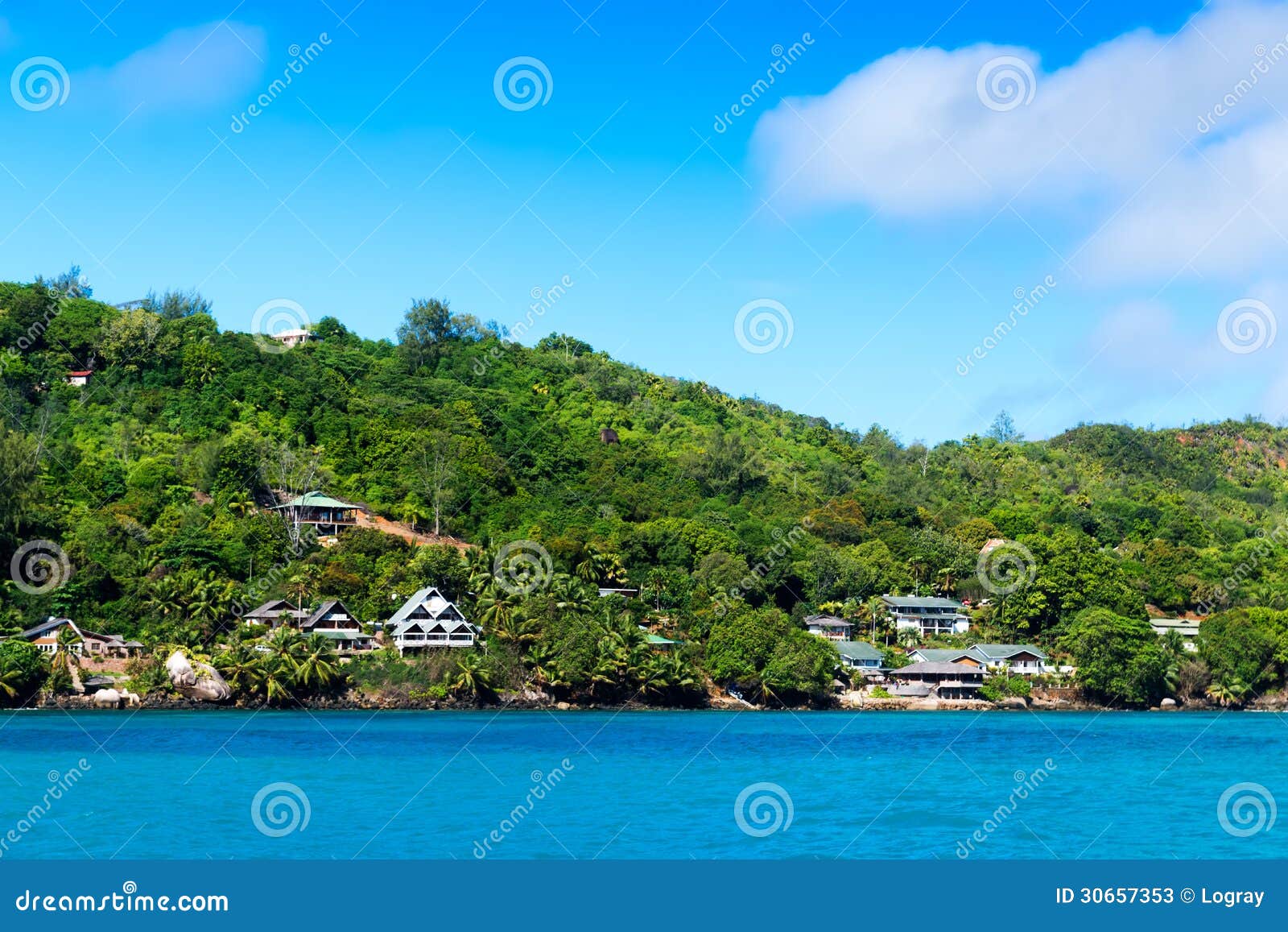 several hotels on green shore of la digue island, seychelles.