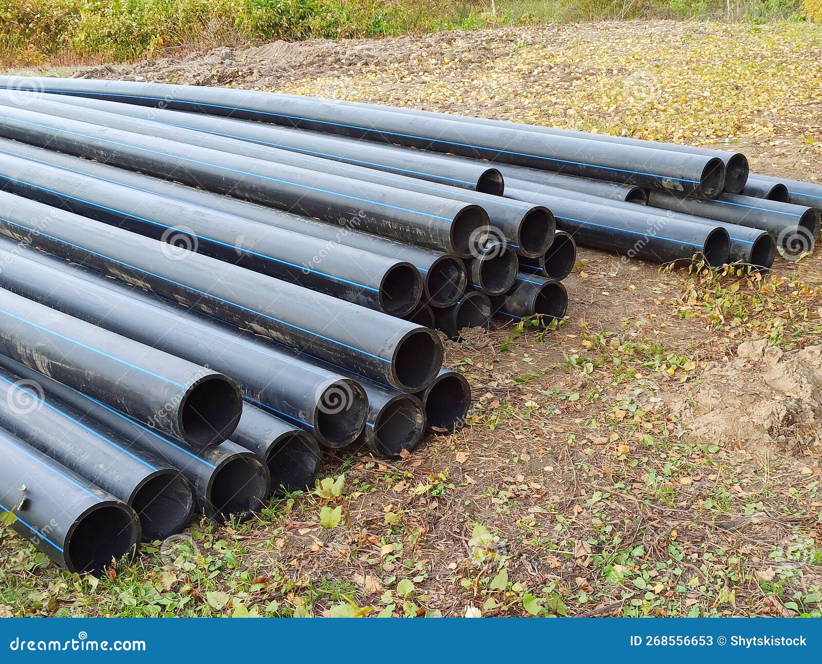 Several New Black Plastic Pipes are Stacked on the Ground. Stock Image