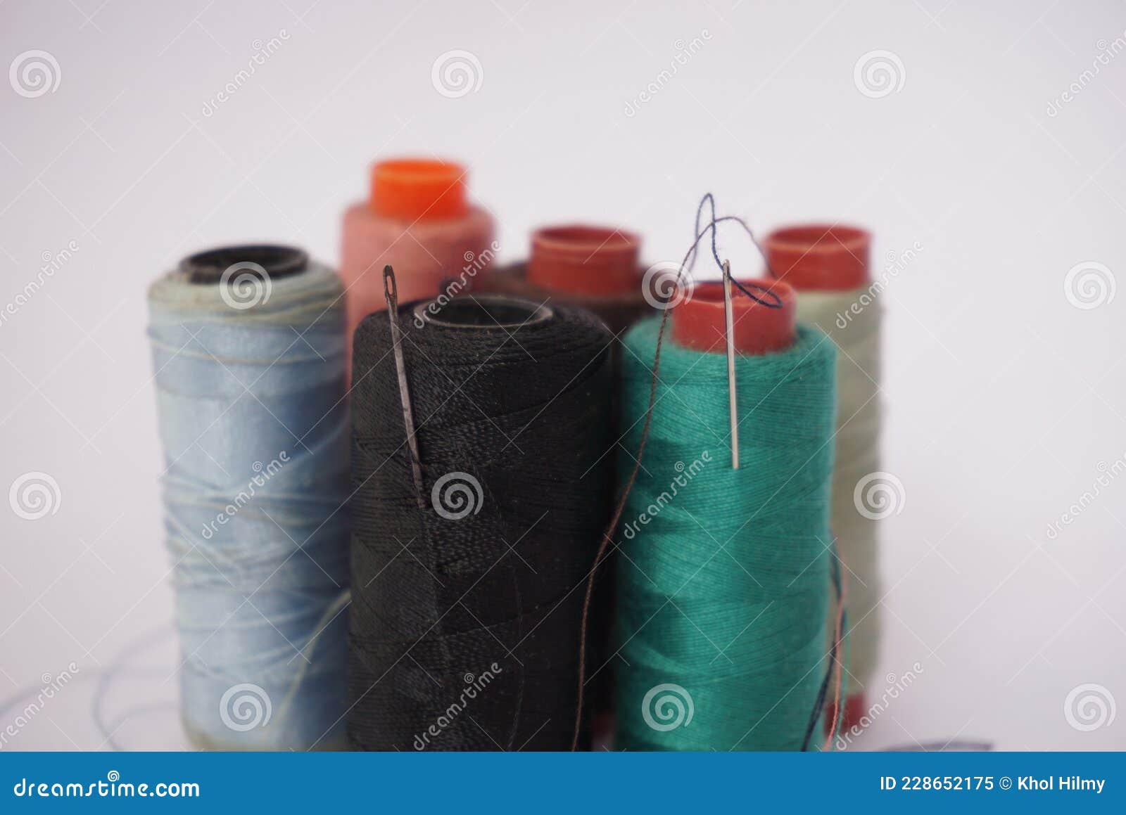 Several Piles of Sewing Thread Spools of Various Colors Isolated on a