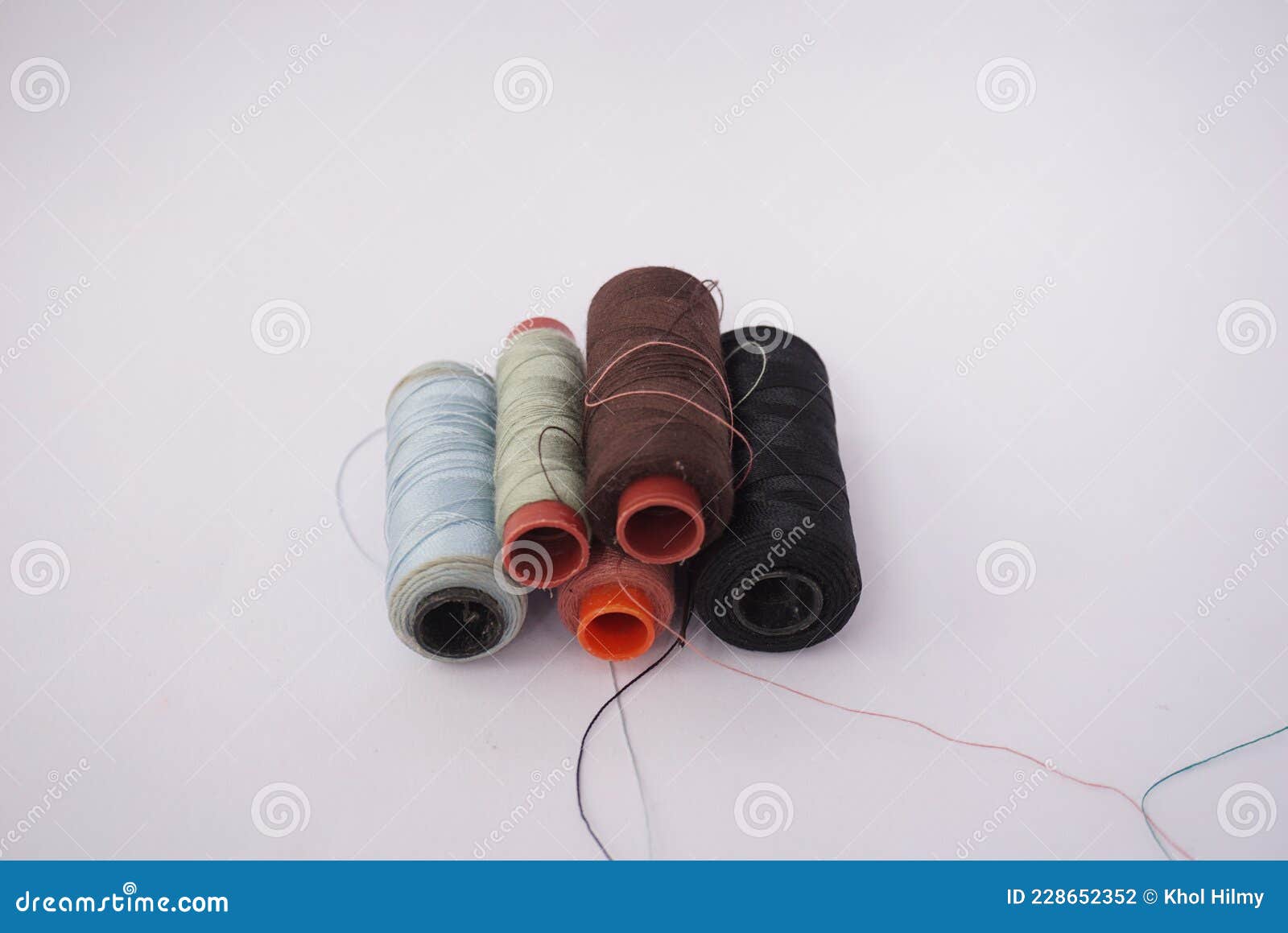 Several Piles of Sewing Thread Spools of Various Colors Isolated on a
