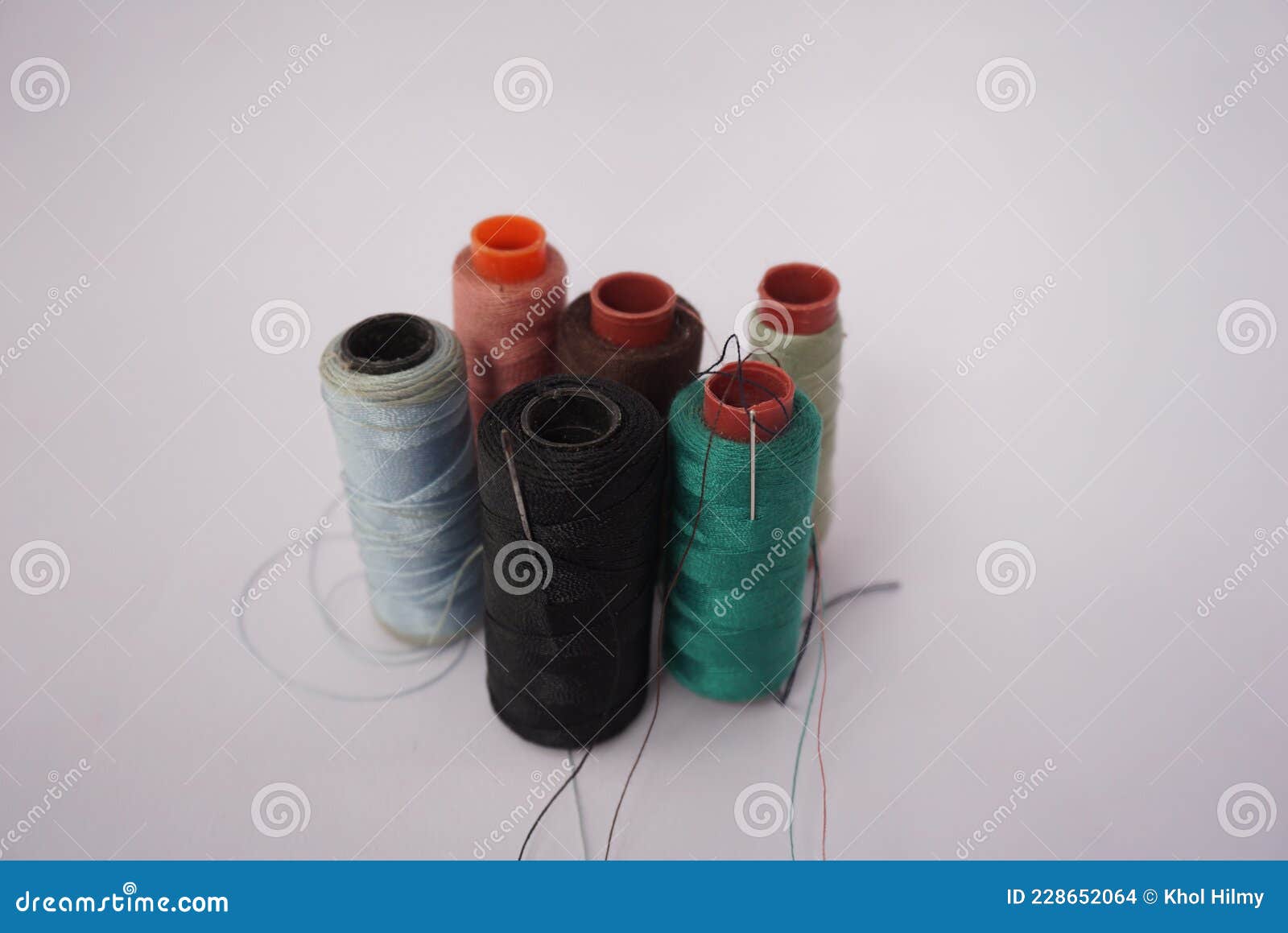 Several Piles of Sewing Thread Spools of Various Colors Isolated on a