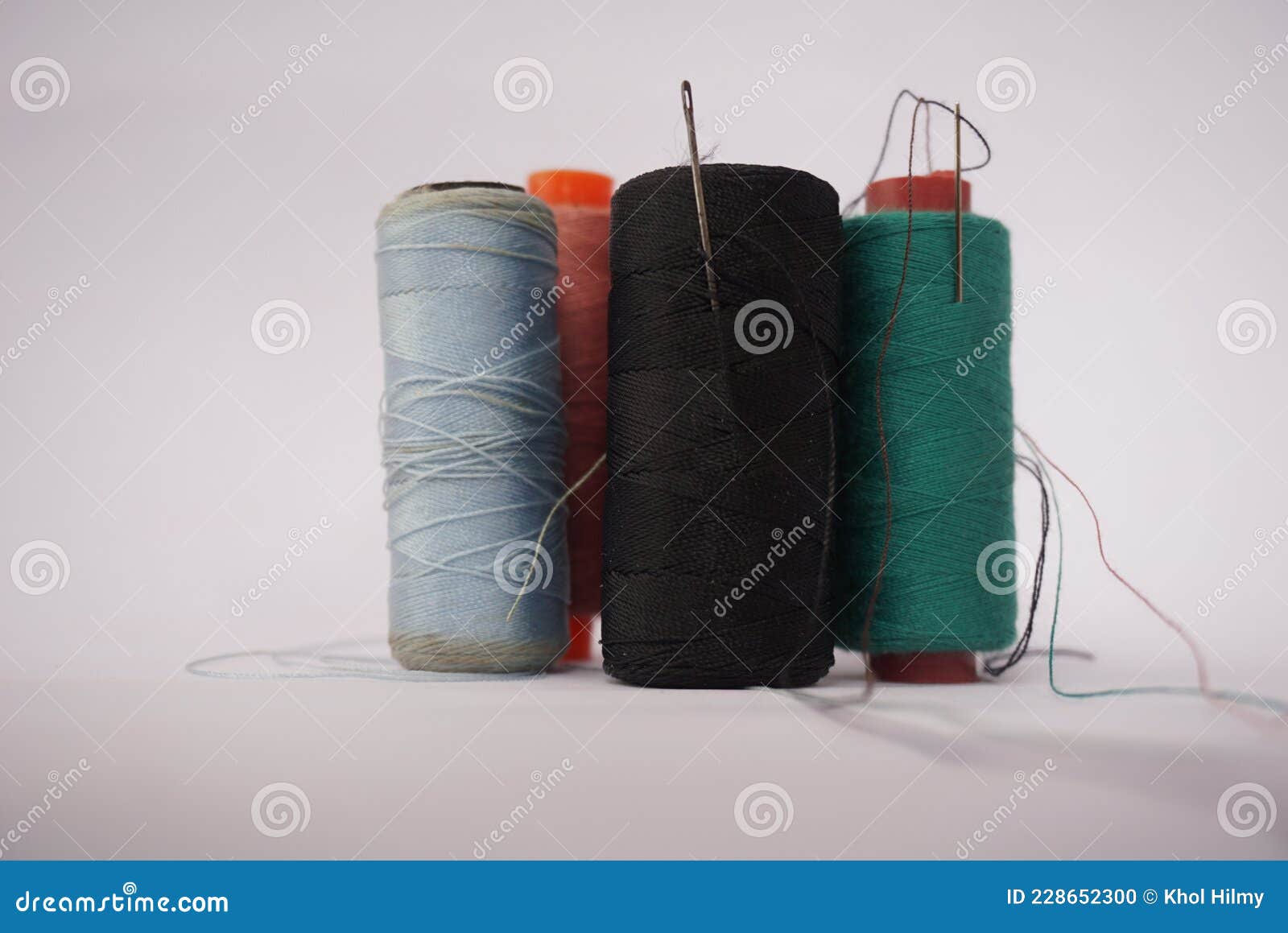 Several Piles of Sewing Thread Spools of Various Colors Isolated on a