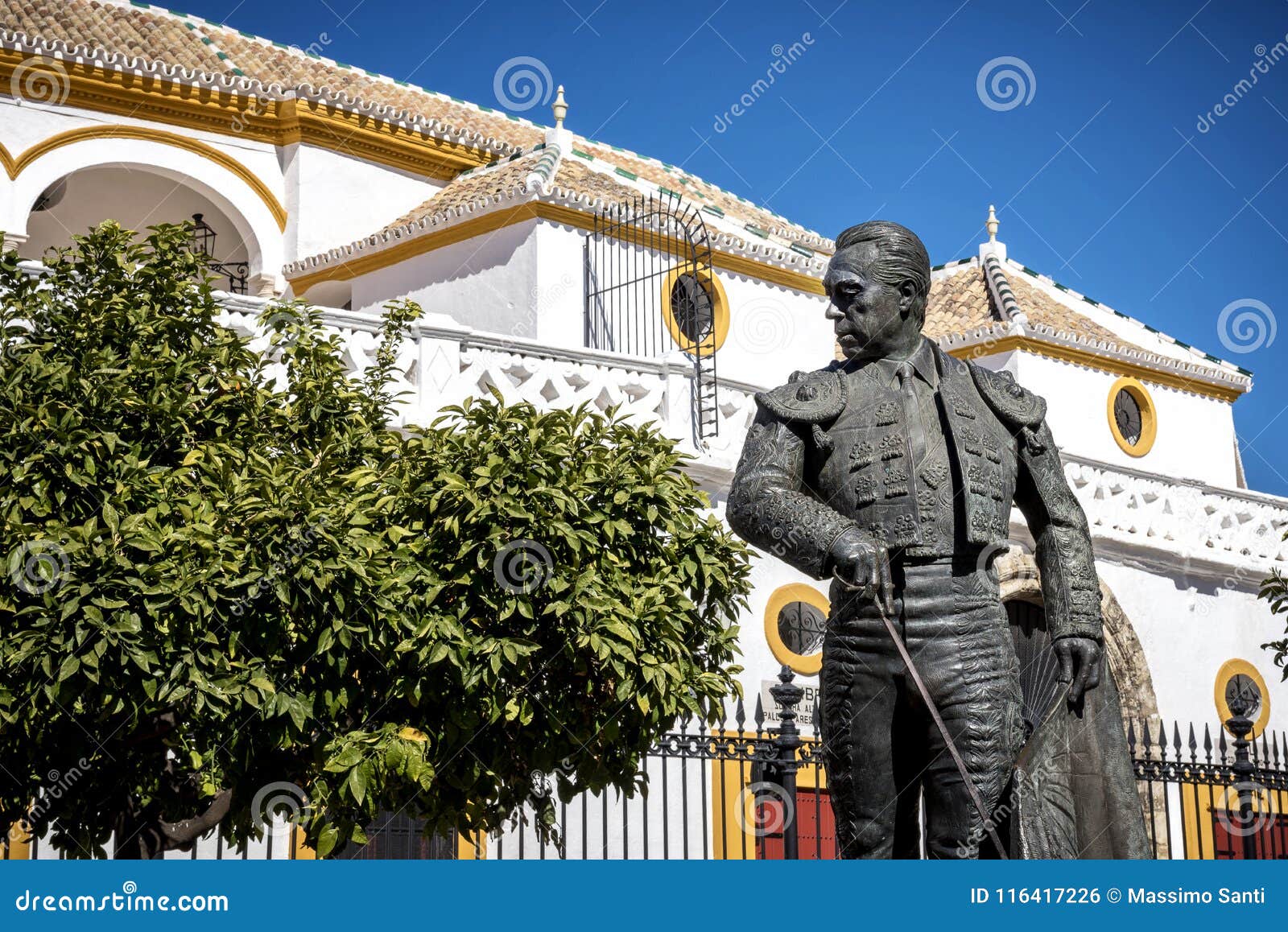 seville, andalusia, spain: the statue of curro romero, a famous torero from seville, in front of plaza de toros de la maestranza