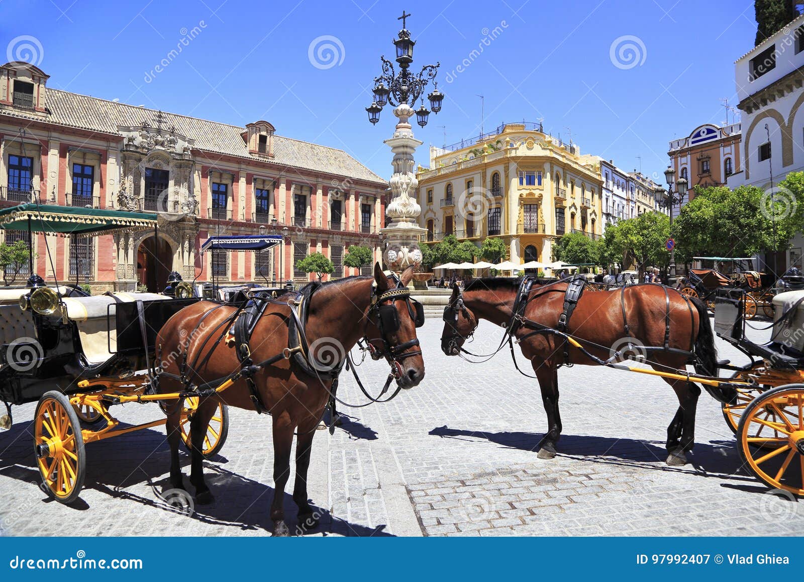 seville plaza with carriages and horses on the foreground