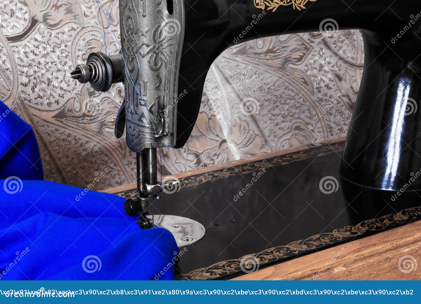 Sewing Head of Antique Sewing Machine and Bright Blue Fabric Stock