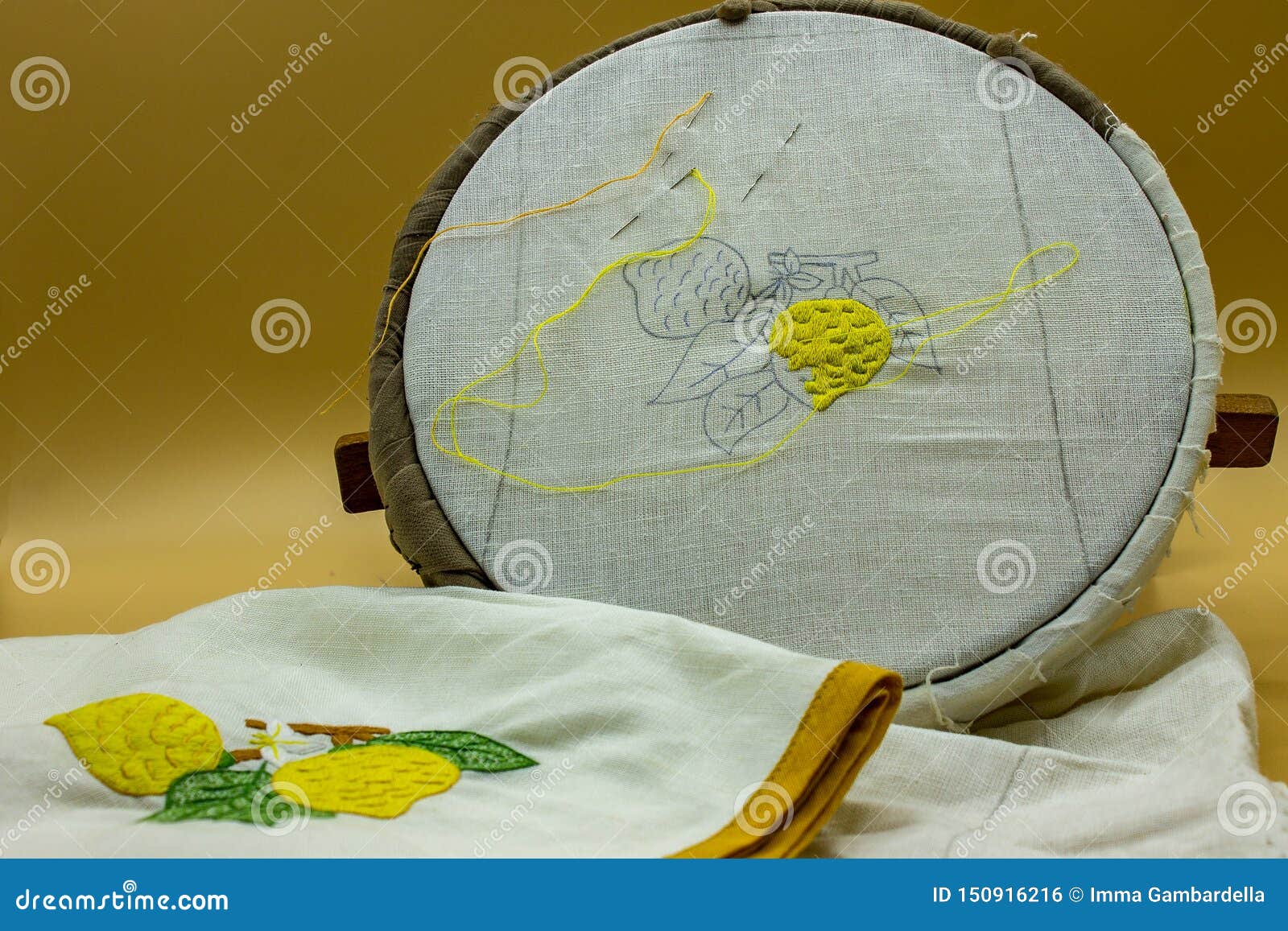 sewing kit, needle, thread. on the frame is visible the canvas on which a lemon is being embroidered, at the end it will be like