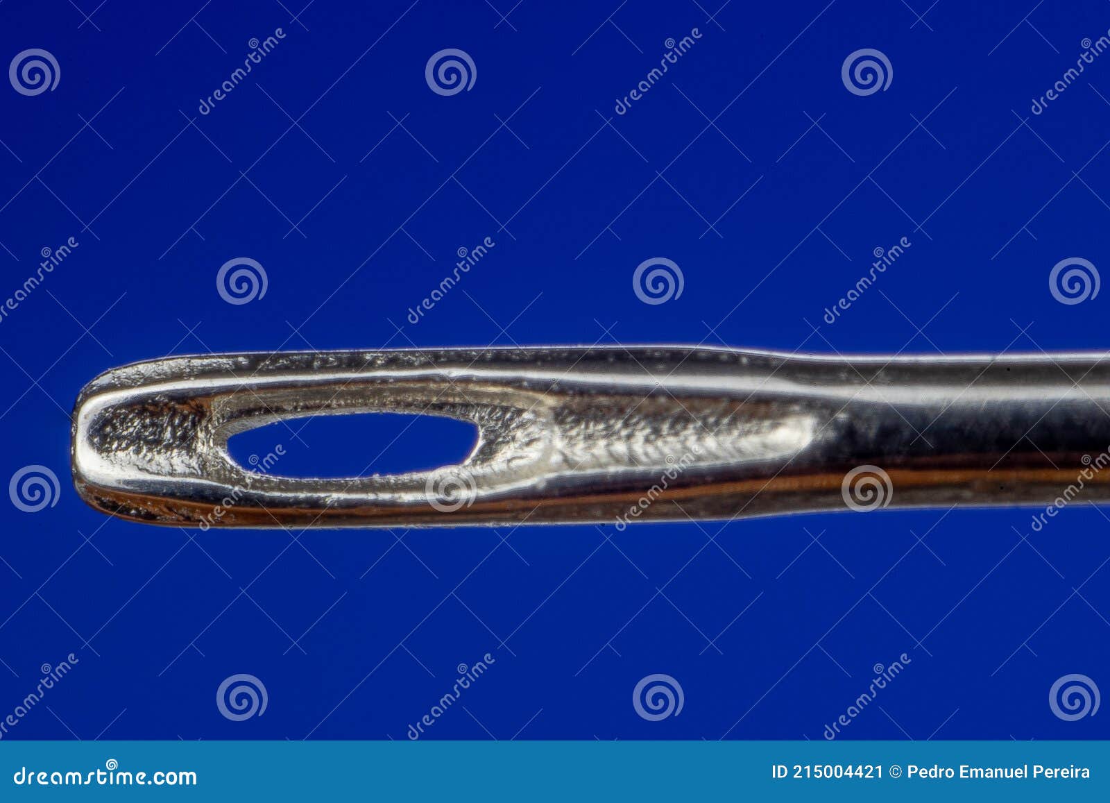 Sewing Needle Eye in the Center of the Blue Background Image Stock