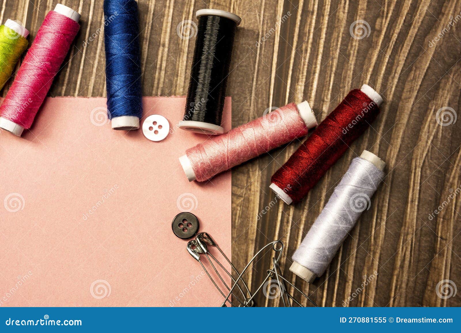 sewing still life with sewing threads and sewing related objects on wooden background