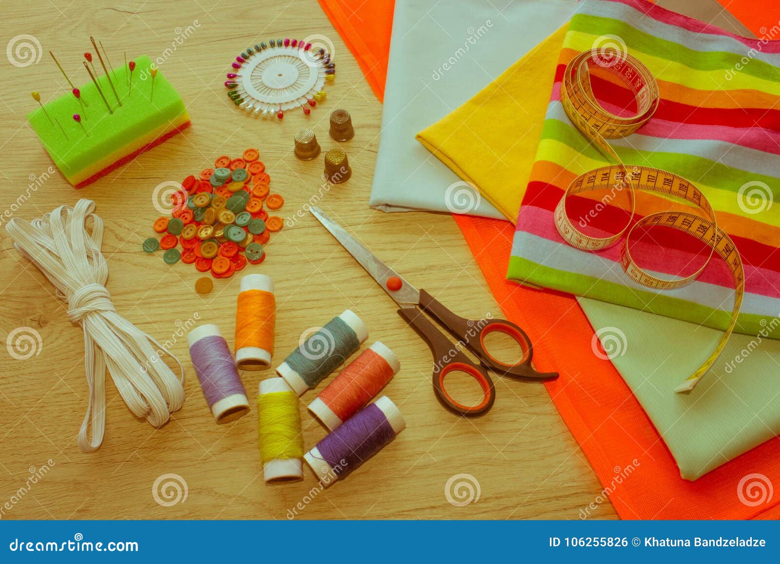 sewing tools and sewing kit on wooden textured background. threa