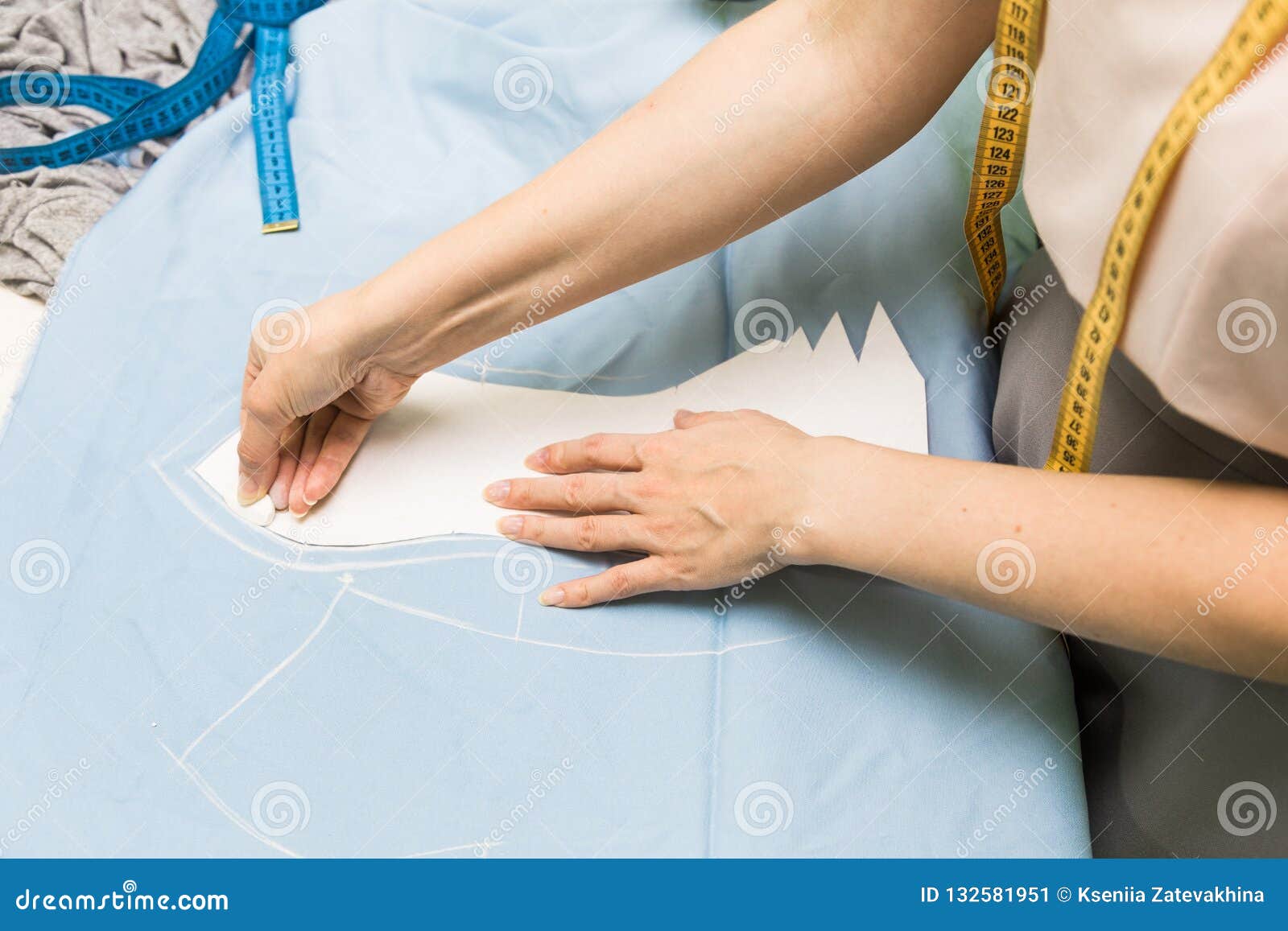 Sewing Seamstress at Work. Marking and Cutting Fabric. Stock