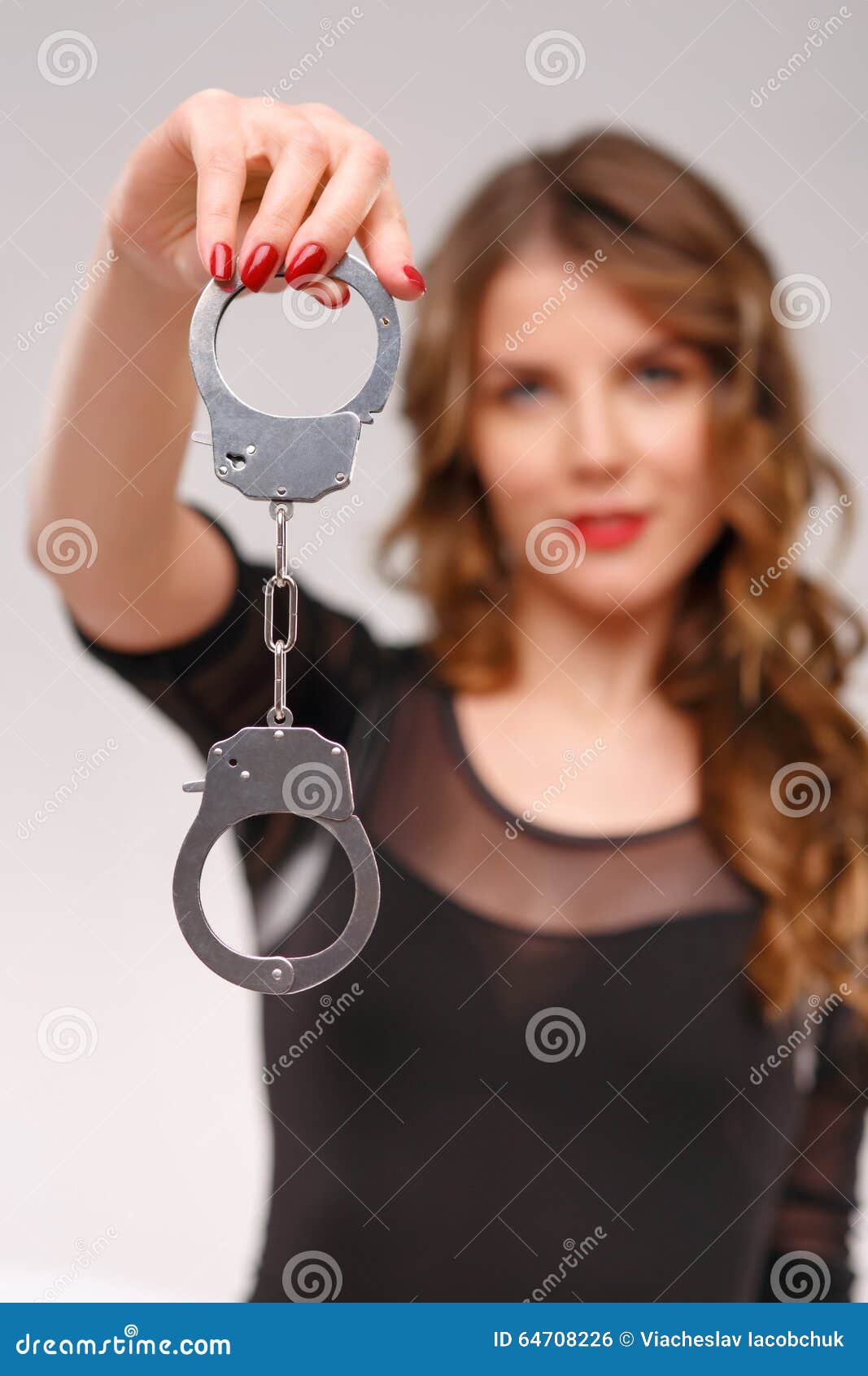 Girl in handcuffs and mask. in color lights. tied hands and