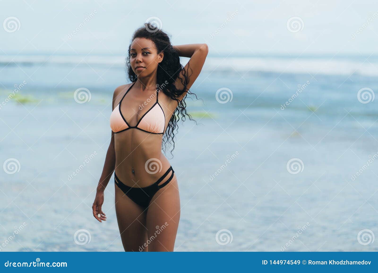 African American Girl in Swimwear Resting on Ocean Beach. Young Black  Skinned Woman with Curly Hair Stands on Stock Image - Image of leisure,  beach: 144974549