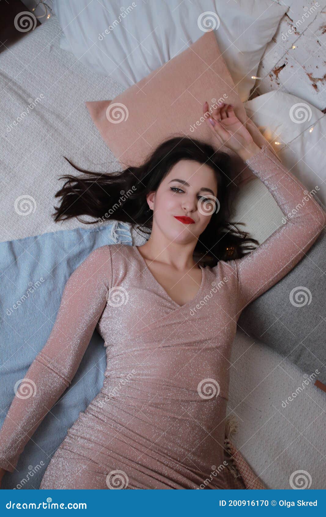 Attractive Brunette In Beige Dress Lying On A Bed Studio Shoot Stock Photo Image Of Desire