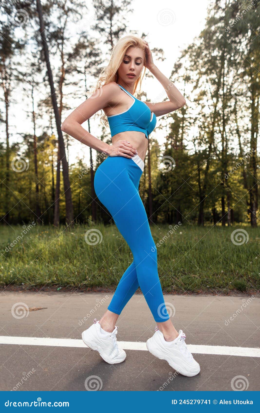 Young caucasian blond-haired woman in sportswear is doing yoga in