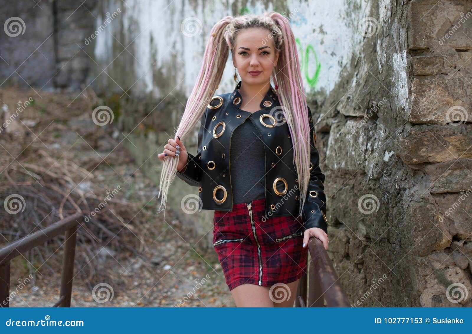 A Girl With Dreadlocks In A Leather Jacket And A Short Skirt