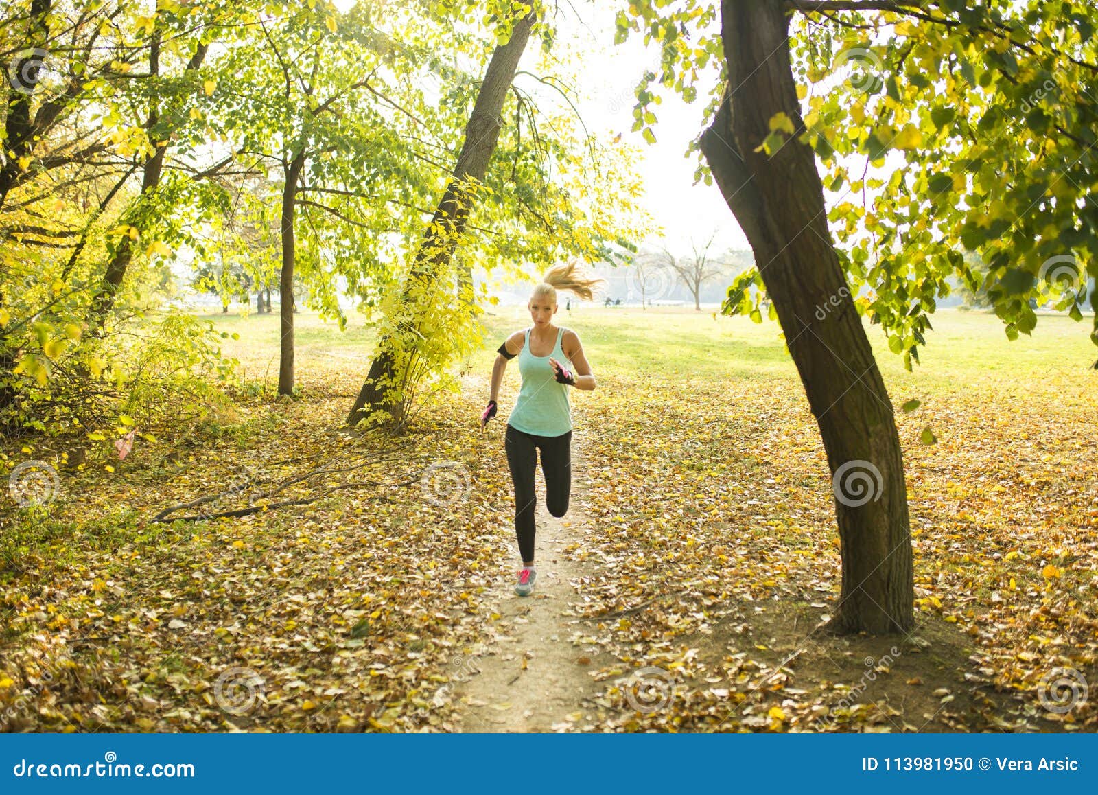Blonde running in the park stock photo. Image of fashionable - 113981950