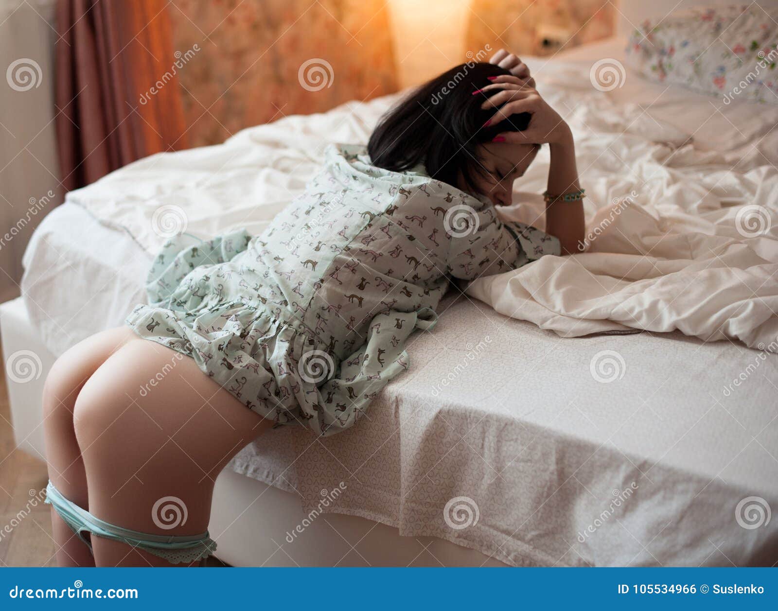 Brunette Girl with Nude Buttocks Lying on the Bed Stock Photo pic