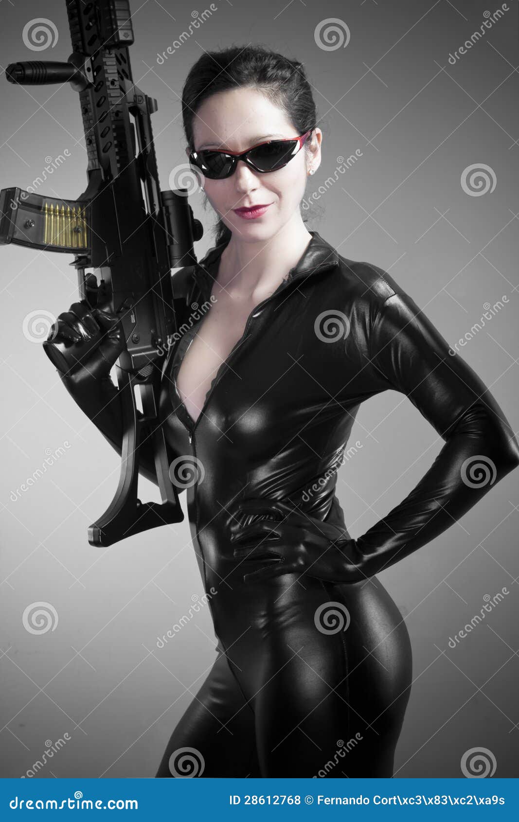 Sexy Brunette Woman In Latex Jumpsuit With Heavy Gun