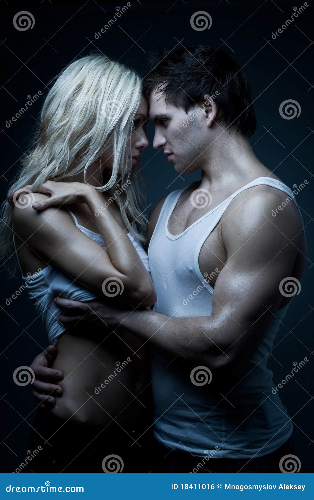 Photo about Muscular handsome guy with pretty woman, on dark background, gl...