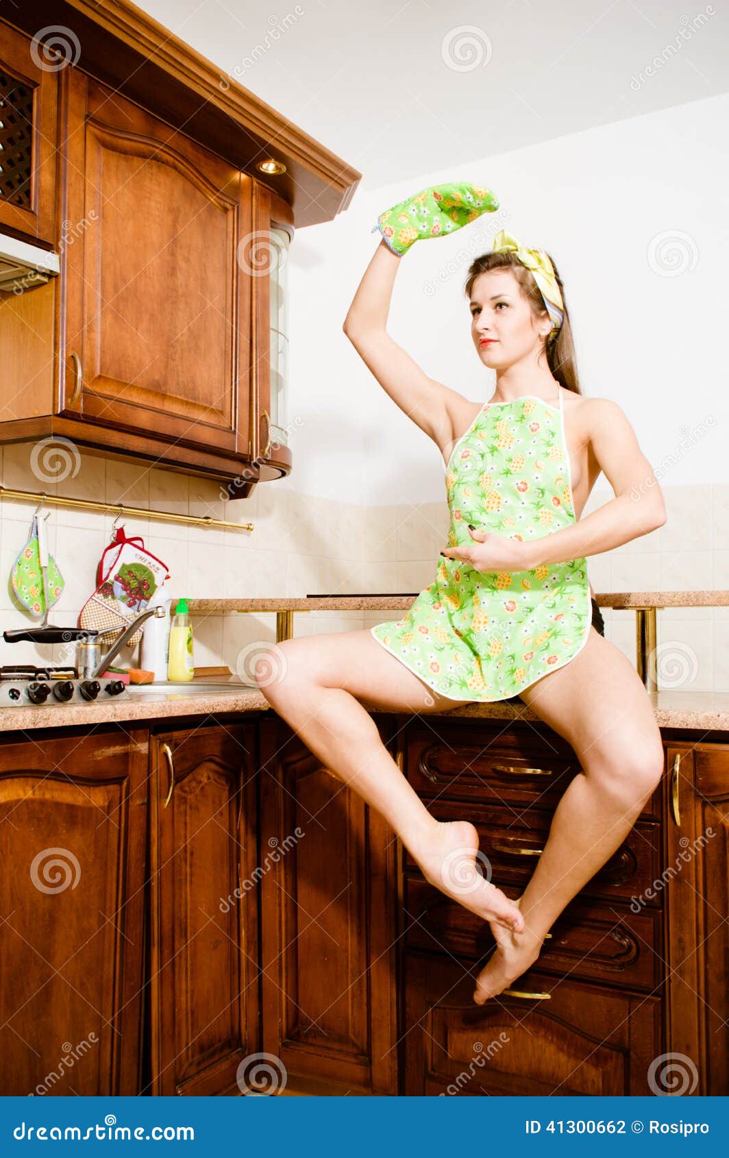 Dancing Girl Sitting On The Table In The Kitchen Apron