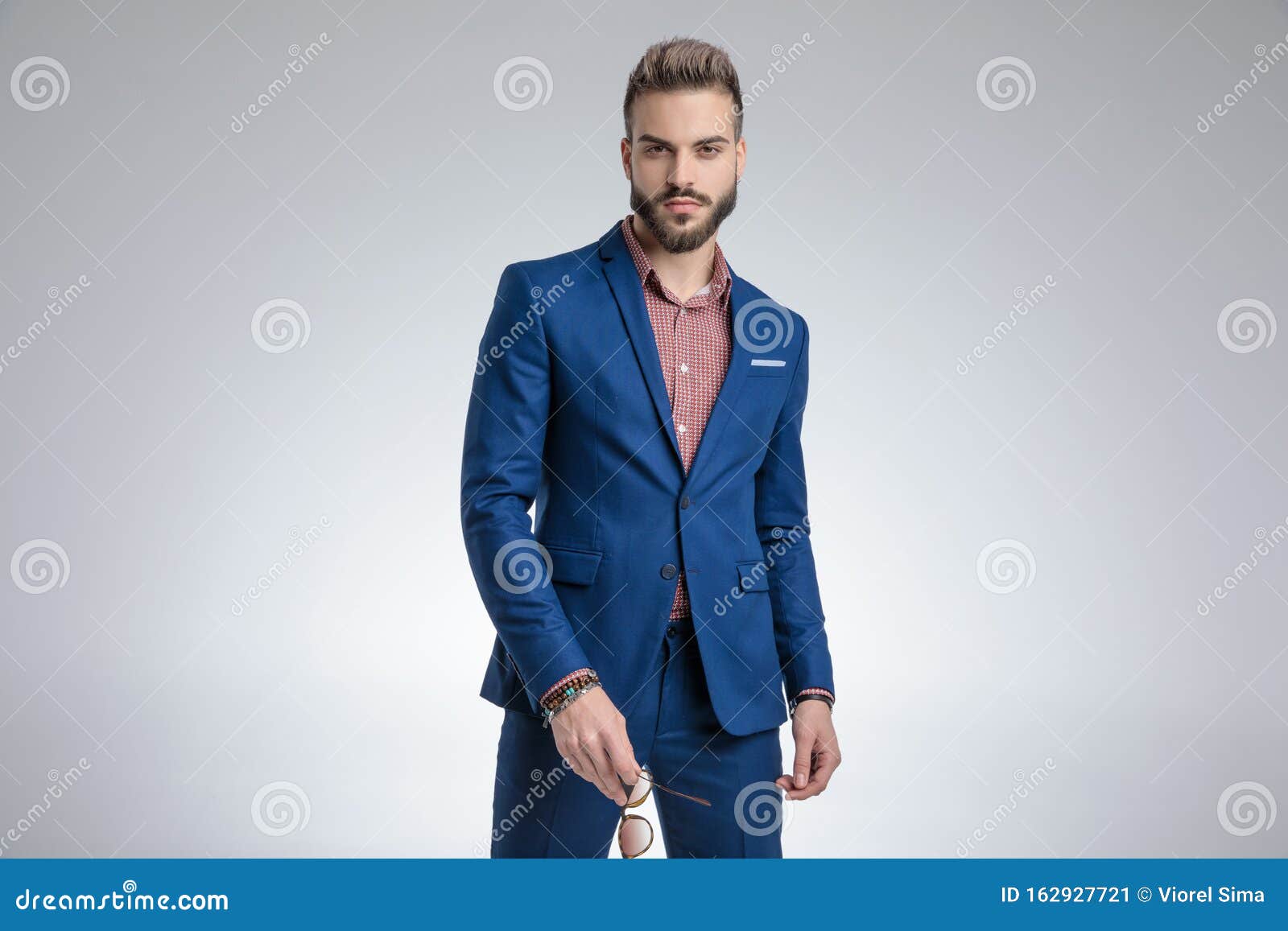 Elegant Man Wearing Blue Suit and Standing in a Fashion Pose Stock ...
