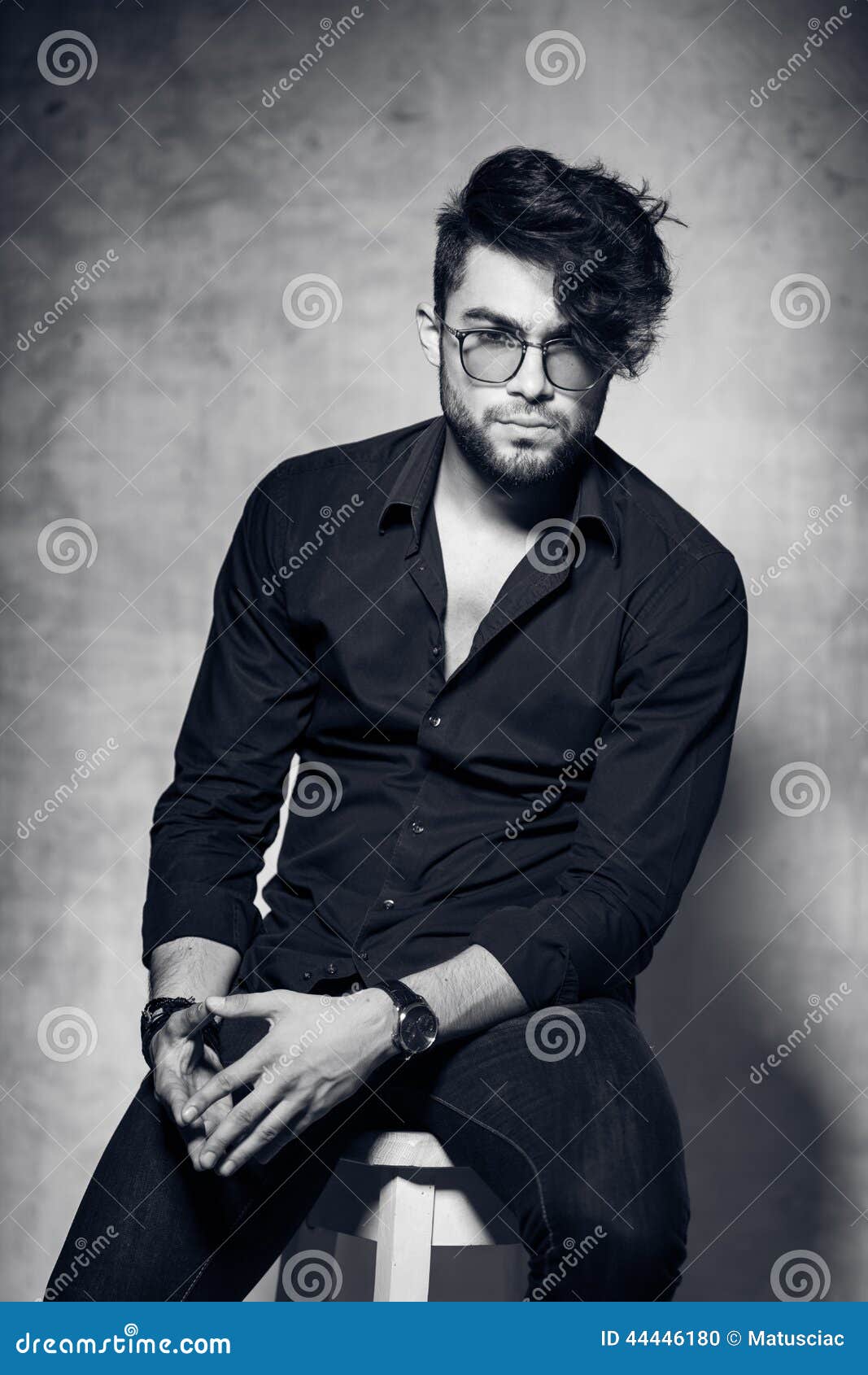 sexy fashion man model dressed casual wearing glasses posing dramatic against grunge wall 44446180