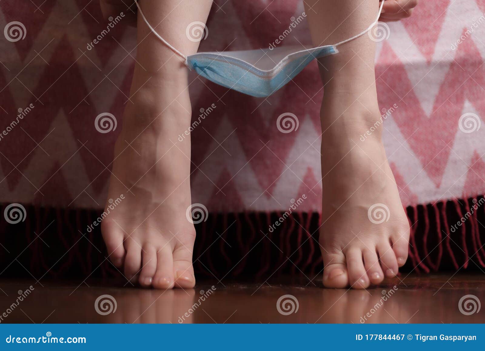 Woman with pink toenails taking off panties Stock Photo by