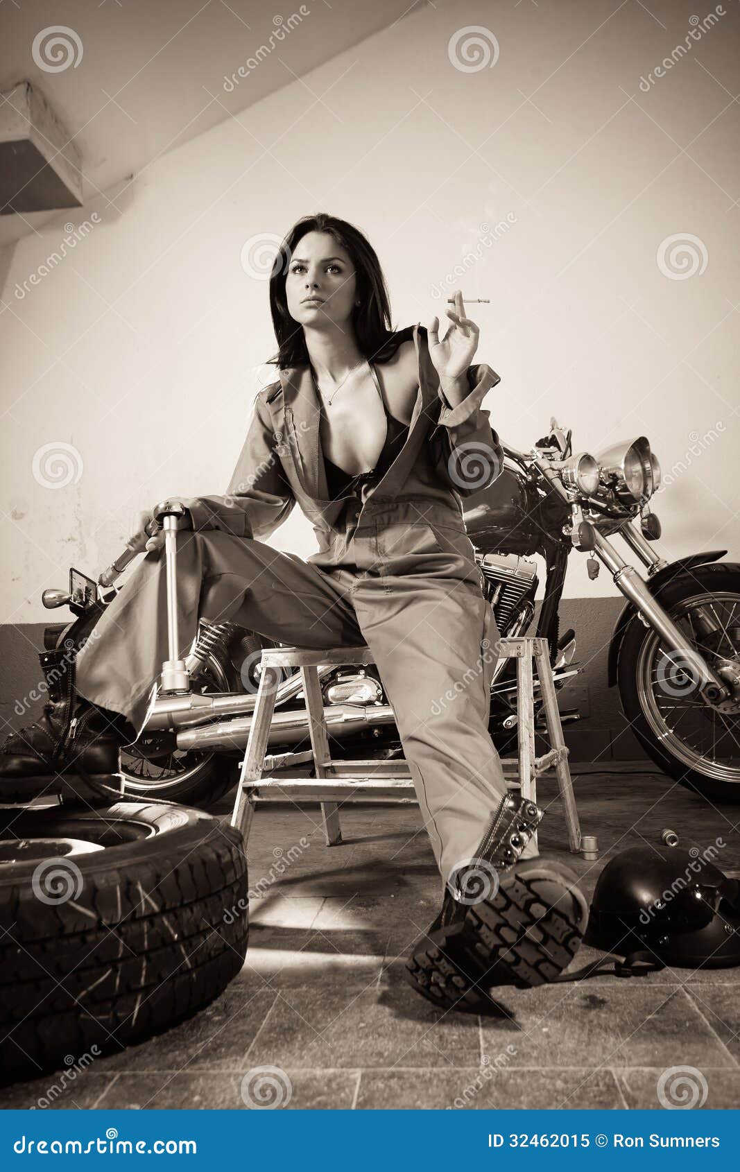 Photo about Photo of a beautiful female mechanic wearing overalls, leather ...
