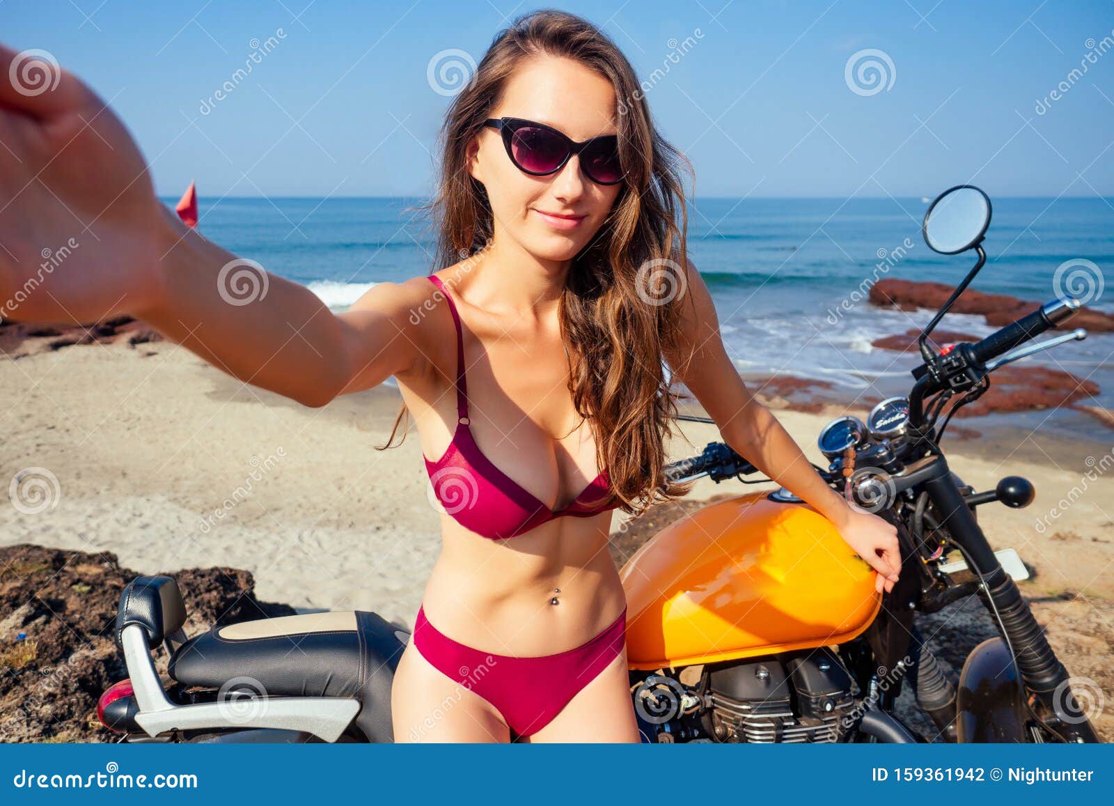 Sexy Girl in Einem Roten Bikini Badeanzug Sitzend Auf Einem  Motorradkönigsfeld Und Nimmt Ein Selbstportrait Auf Einem Smartphone  Stockfoto - Bild von sand, motorrad: 159361942